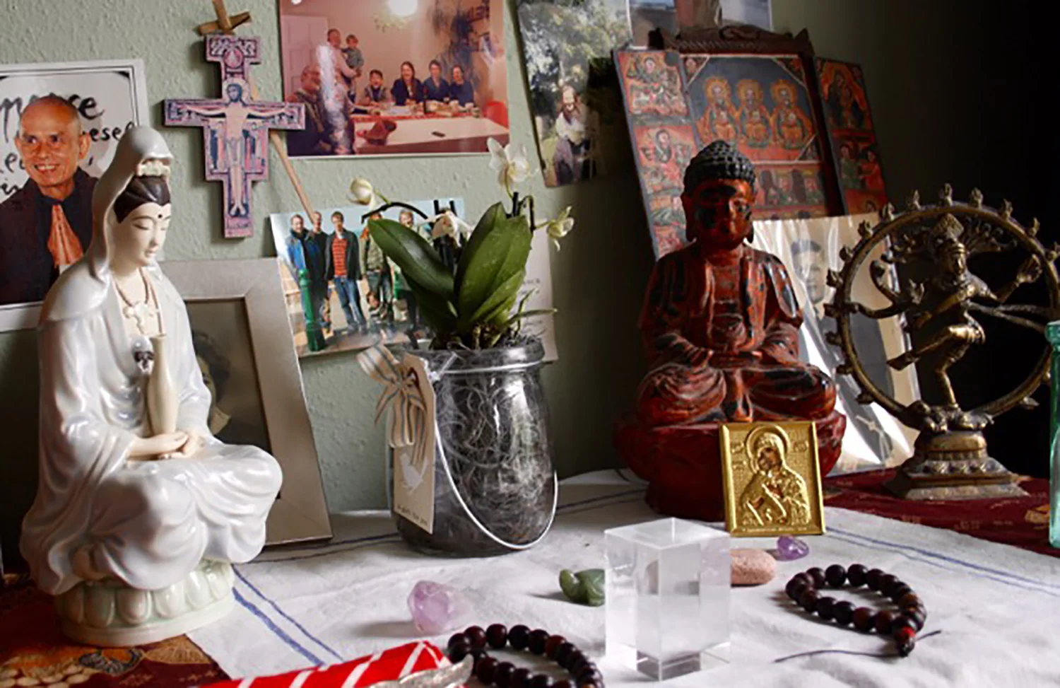 A modern home altar in the “New Age” tradition. In addition to a number of family photos, the altar includes objects from Buddhist, Catholic, Hindu, Orthodox, Ethiopian Orthodox, Tibetan and Chinese traditions. Photo: Crispin Paine.
