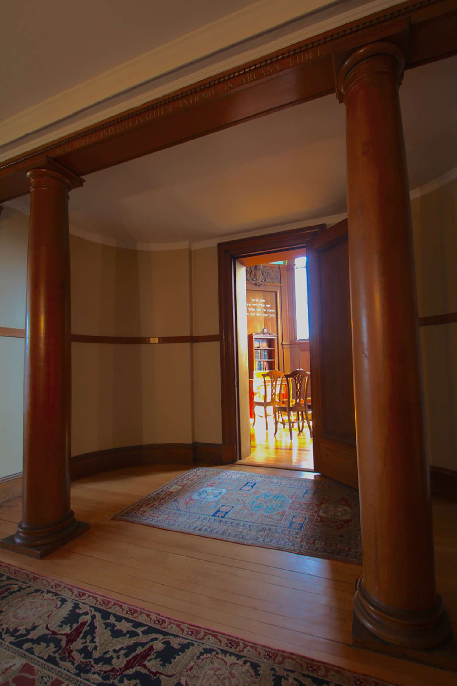 Figure 2: The entrance to the Cairnwood chapel lies beyond two columns of wood, beneath an architrave painted with an inscription in Latin from the theological works of Emanuel Swedenborg (1688-1772). ( Nunc licet intellectualiter intrare in arcana fidei ; “Now it is permitted to enter with understanding into the mysteries of faith.” True Christian Religion 508.) Swedenborg emphasized that people should read and study the Bible for themselves, and not simply accept the authority of others.