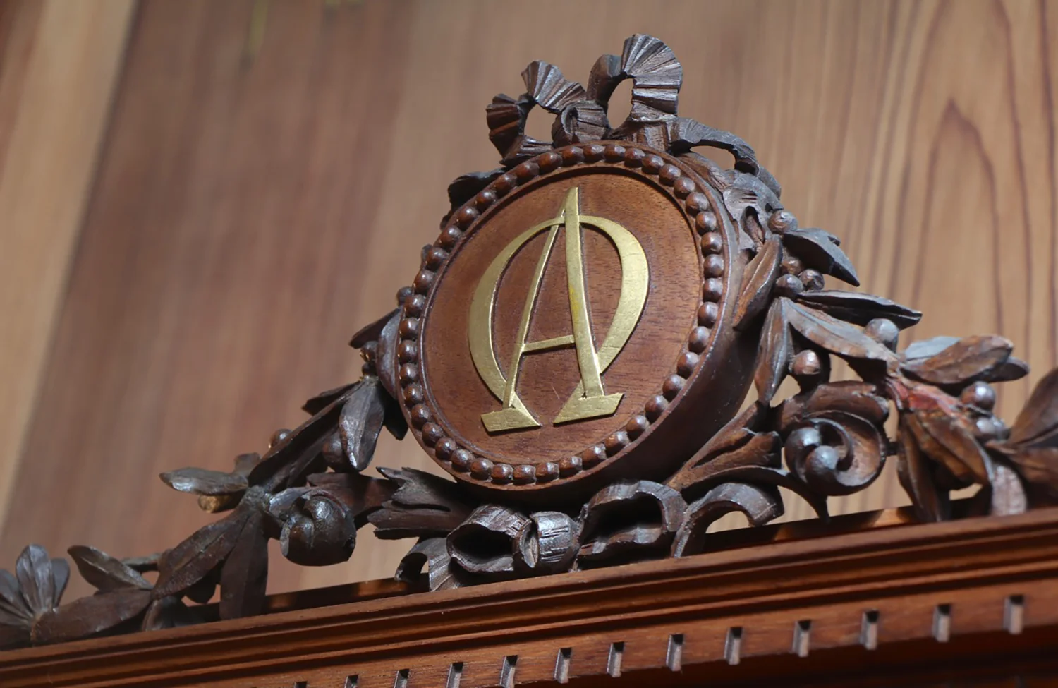 Figure 4: The Bible cabinet is carved with alpha and omega , the first and last letters of the Greek alphabet. In the New Testament’s Book of Revelation, God says, “I am the Alpha and the Omega, the beginning and the end” (1:8).