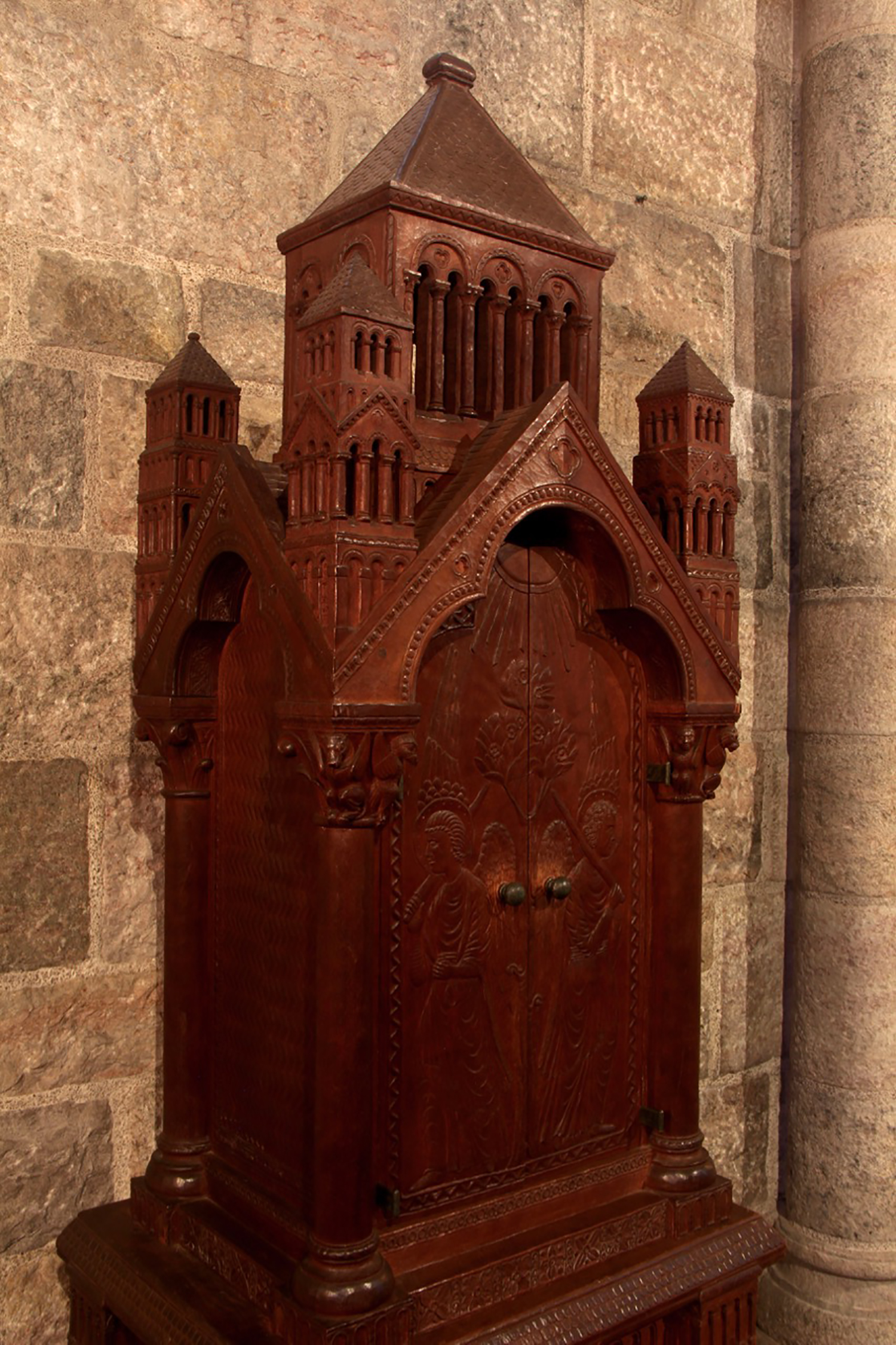 Figure 10: The doors on this cherrywood Bible cabinet, made for Glencairn’s chapel by woodcarver Frank Jeck, feature images of the angels who stood guard at the entrance to the garden of Eden. The two small wood-carved capitals depicting the four living creatures around the throne of God in heaven (Book of Revelation 4:7) are repeated in stone on two large capitals above the cabinet. Both of these themes are repeated elsewhere in the chapel; the angels with flaming swords are also carved in stone at the chapel’s entrance, and the four living creatures are depicted in an elaborate mosaic on the ceiling. This Bible cabinet was made for Glencairn’s chapel around 1926, before construction on the building began in 1928.