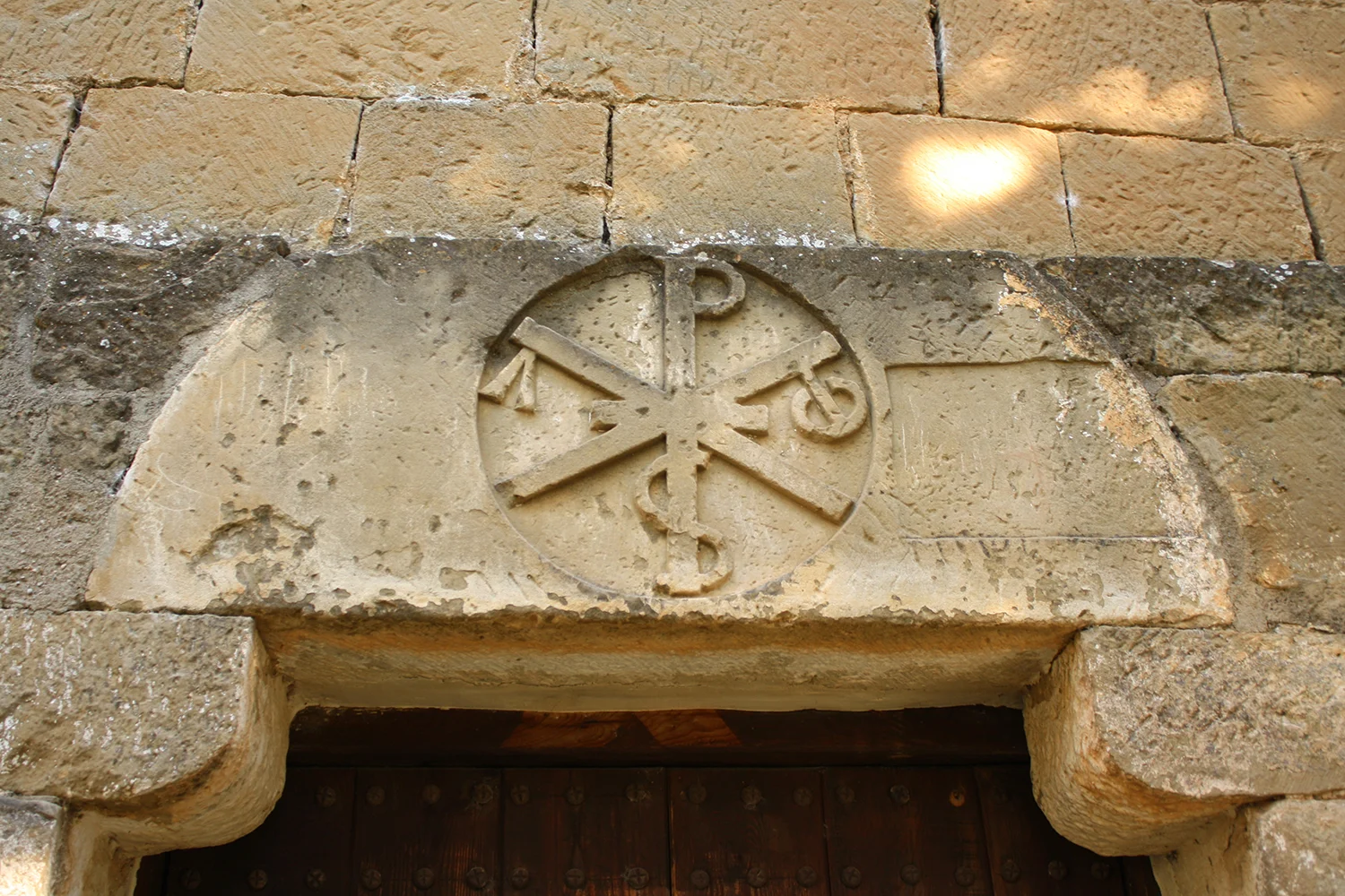 Figure 5: Twelfth-century tympanum with the monogram of Christ incorporating the alpha and omega , placed over the doorway of the church of Santa Cruz/San Martín in Riglos (Aragon), Spain. (Photo by Julia Perratore.)