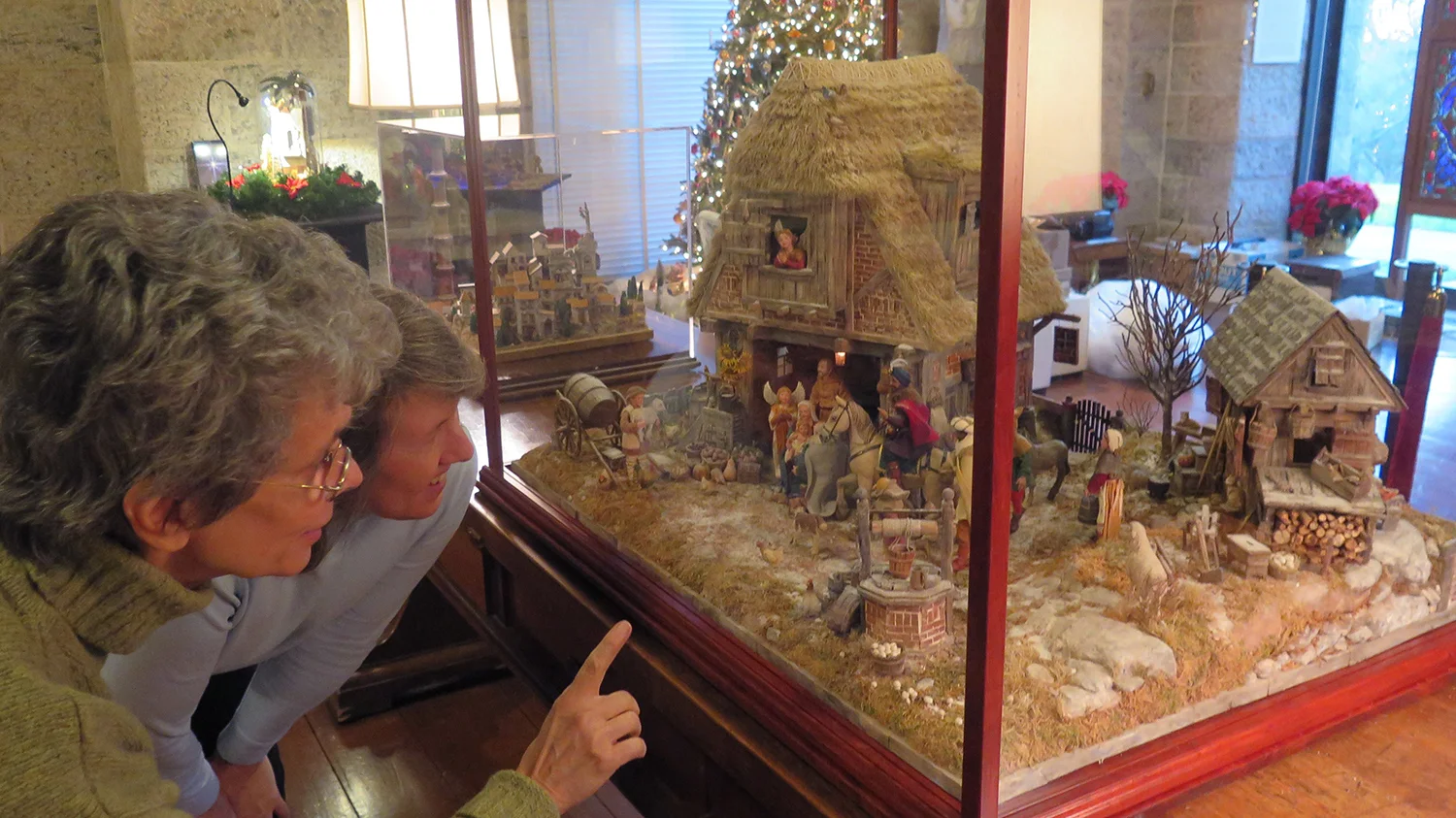 Figure 1: Artist Karen Loccisano (left) and Kirsten Hansen Gyllenhaal, one of the co-curators of the World Nativities exhibition, discuss the Flemish Nativity, made by Karen and her husband, Michael Palan. Photo by R. Michael Palan.