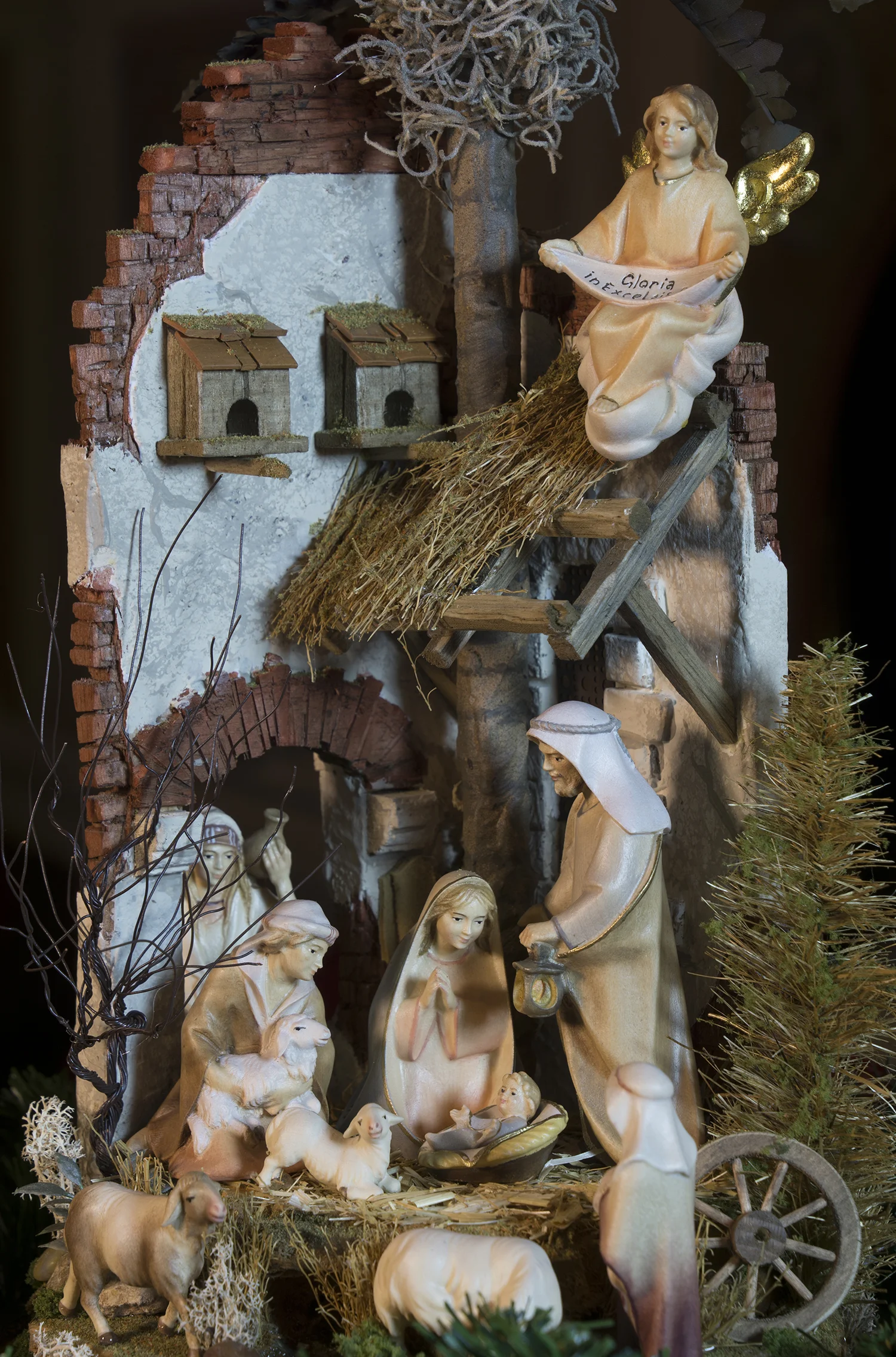 Figure 12: This presentation of a Nativity “in the round,” nestled inside an antique French cloche (a glass covering for garden plants to prevent frost damage), features many finely crafted details, including handmade trees, crumbling ancient bricks, dove houses above the roof, and a small stream. The setting was created by Navidad Nativities of Bucks County, Pennsylvania, and the figures were carved from mountain maple and painted in the studios of Ulrich Perathoner at Val Gardena in the Italian Alps. On loan from Navidad Nativities, Bucks County, Pennsylvania. 
