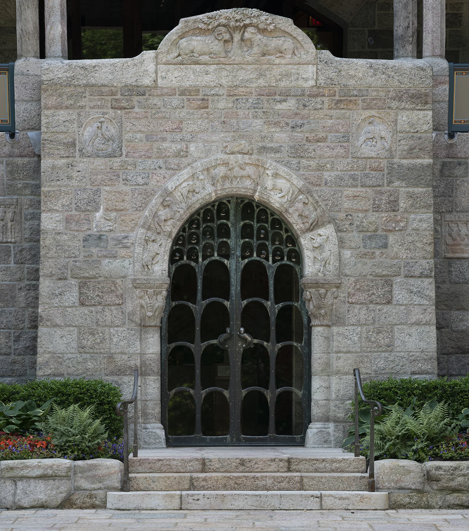 Figure 20: Glencairn's lintel in its final location above the front door. A ram and ewe rest under a spreading tree with "Glencairn" engraved below.