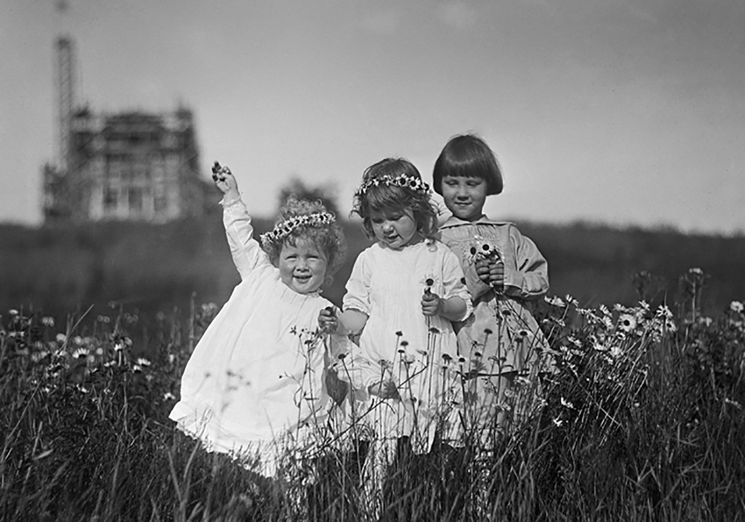 Ivan, Gabriele and Nathan Pitcairn make daisy chain crowns down the hill from Bryn Athyn Cathedral. Raymond, their father, was the photographer (circa 1917).