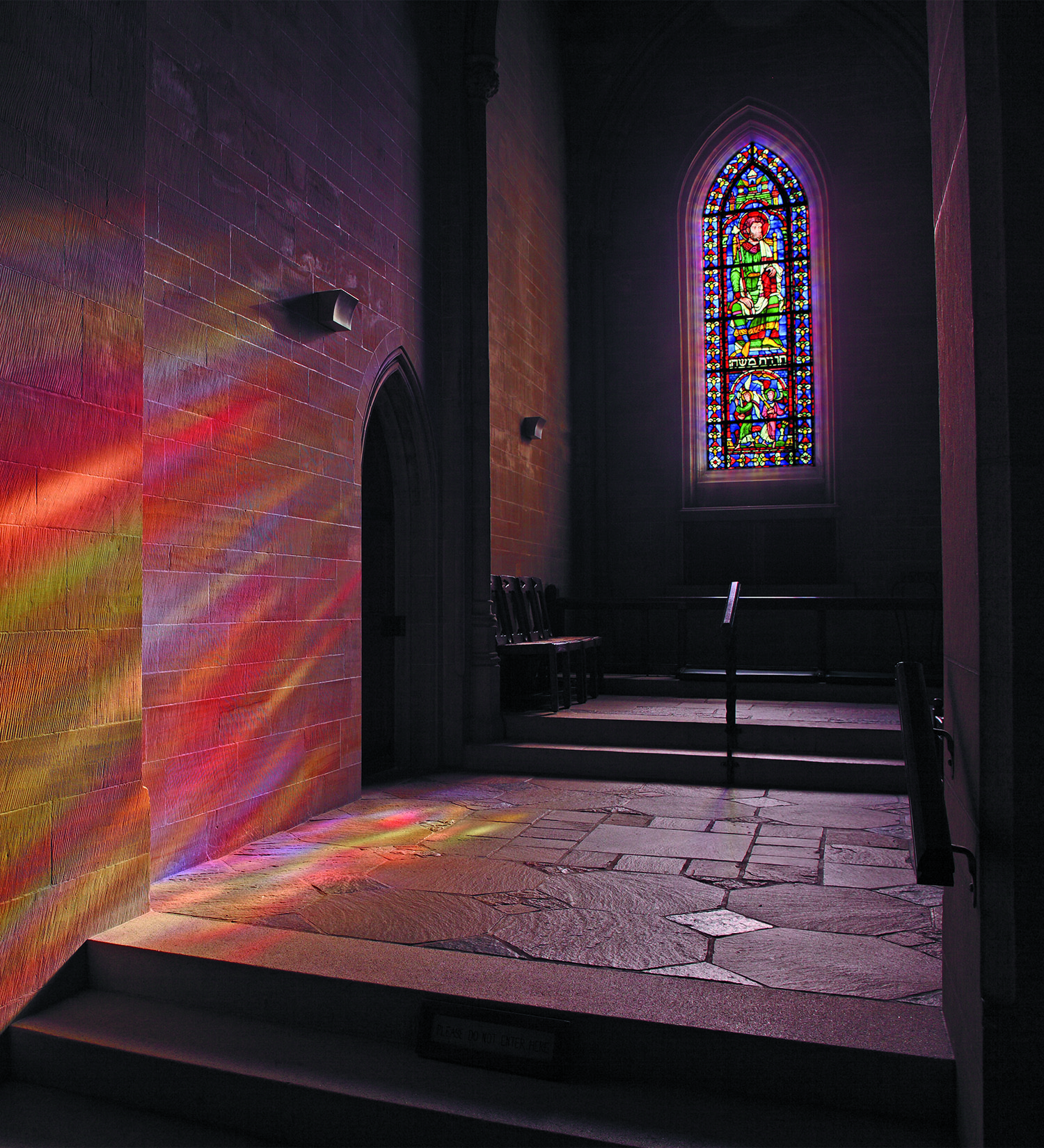 Light streams through the north chancel aisle window in Bryn Athyn Cathedral, bathing the sandstone wall in a rainbow of colors. Photograph courtesy of Hal Conroy.