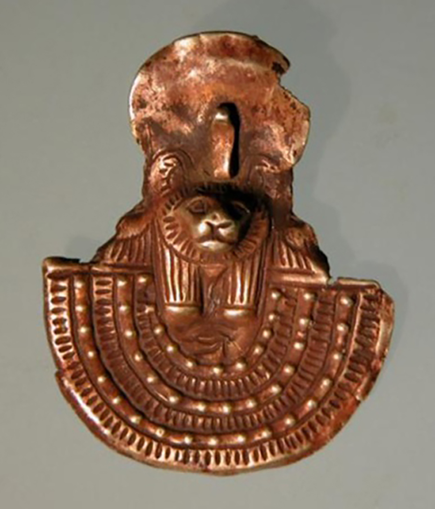 Figure 17: Gold amulet of an aegis with a leonine head from Meydum, Egypt, Late Period (664-332 BCE). Penn Museum 31-27-272.