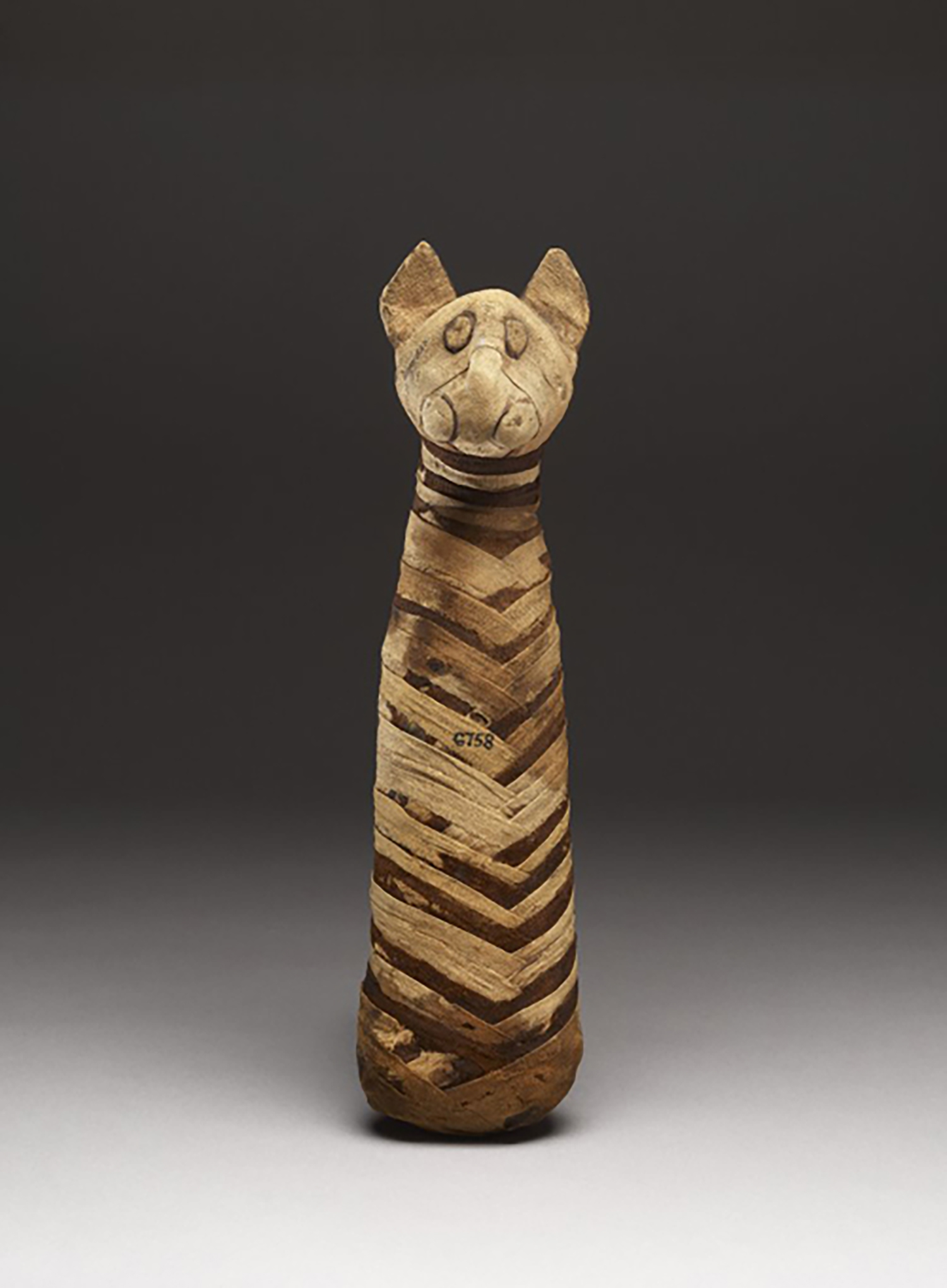 Figure 19: Cat mummy with modeled head and linen wrappings, Roman Period (post 30 BCE). British Museum EA6758. Image courtesy of the British Museum.