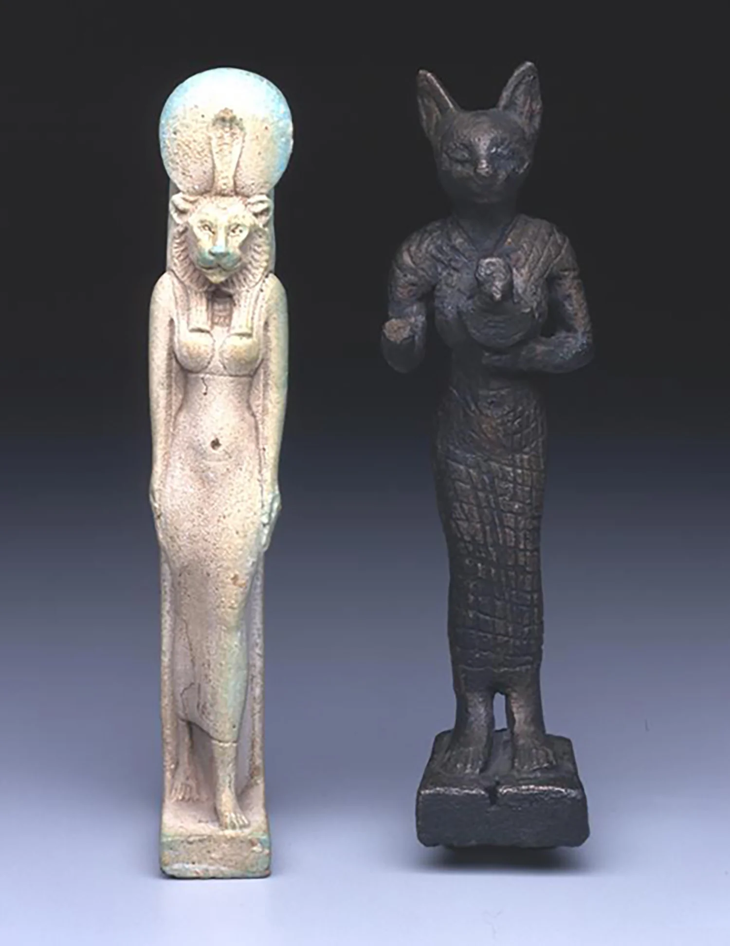 Figure 25: A faience amulet of Sekhmet, post Third Intermediate Period (after 656 BCE) and a bronze votive statuette of Bastet, Late Period (664-332 BCE). Penn Museum E14357 and 29-70-695.