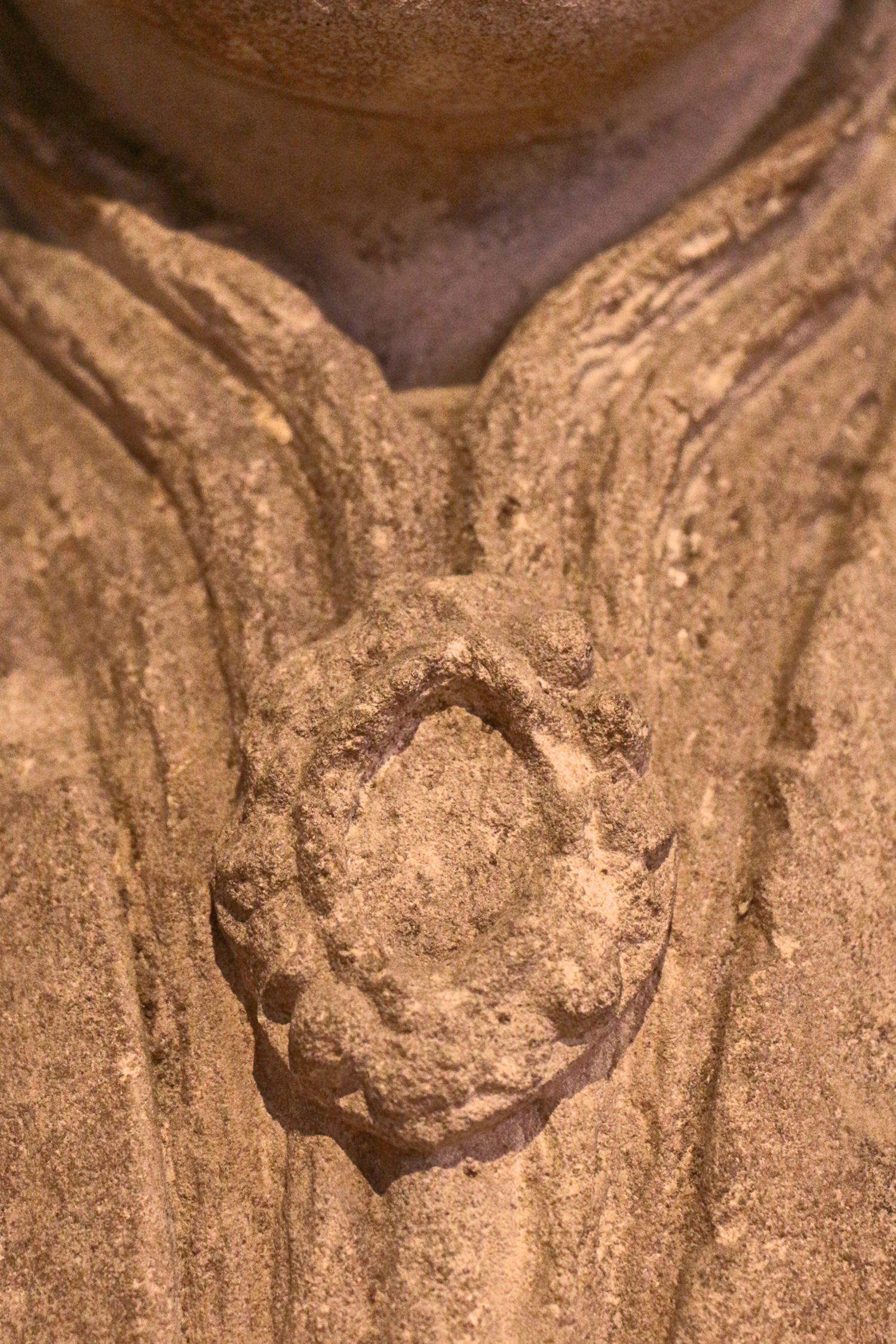 Figure 7: An ornate, jeweled brooch is positioned at the throat of the figure.