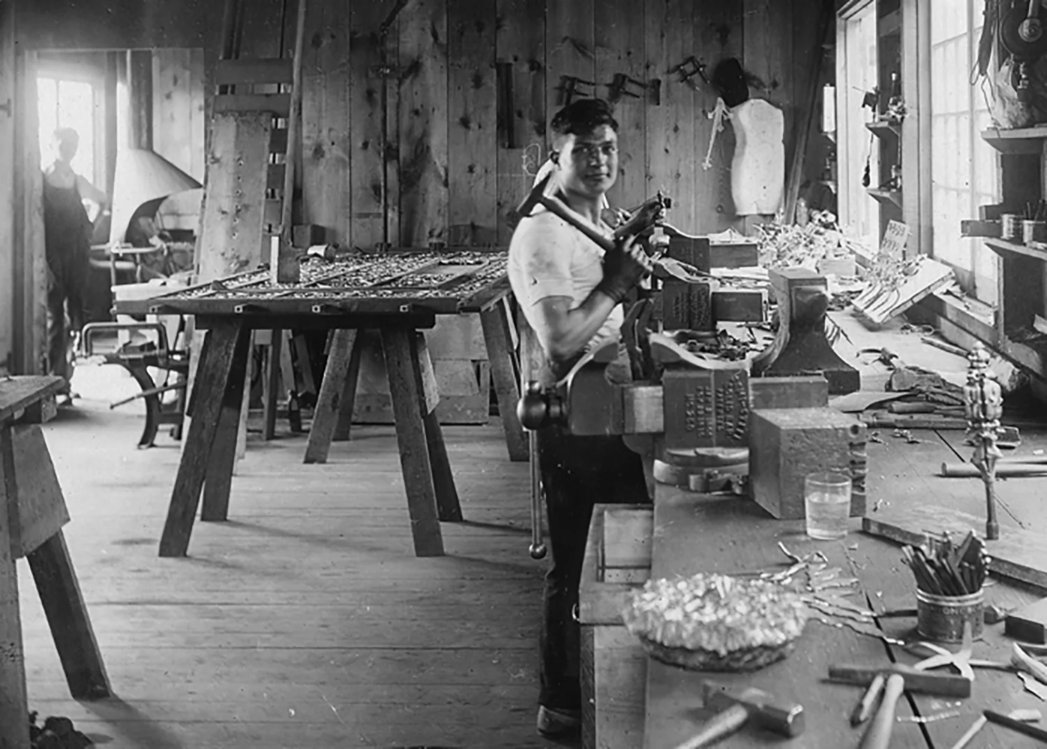 Figure 15: An interior view of the Bryn Athyn Studios metalwork shop, which was built after a fire in 1916 destroyed the original blacksmith shop. The forge is visible through the doorway into the next room.