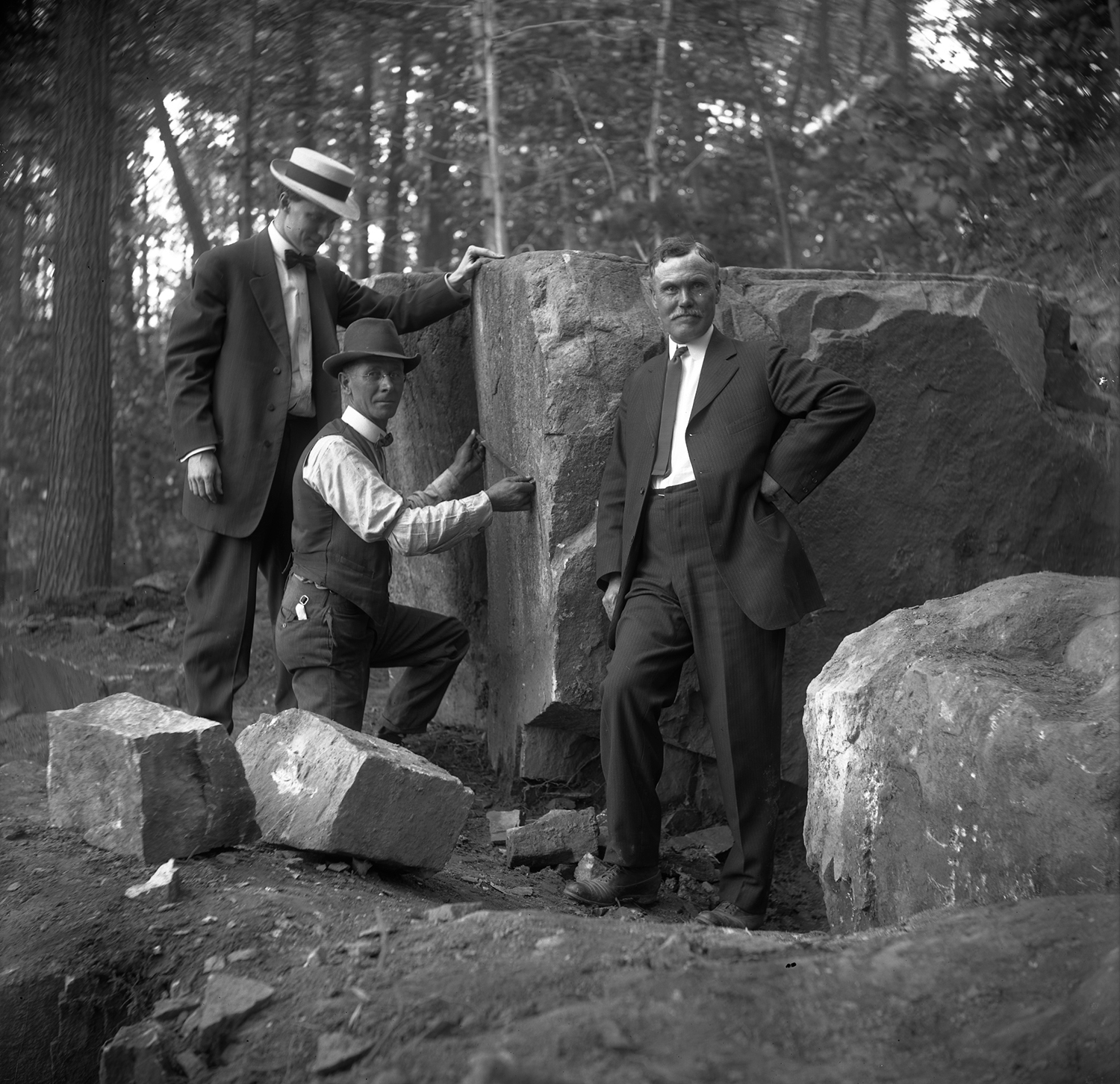 Figure 1: From left to right, Raymond Pitcairn, Edward Kessel, and Pringle Borthwick measure the cornerstone before it is split from the larger boulder.