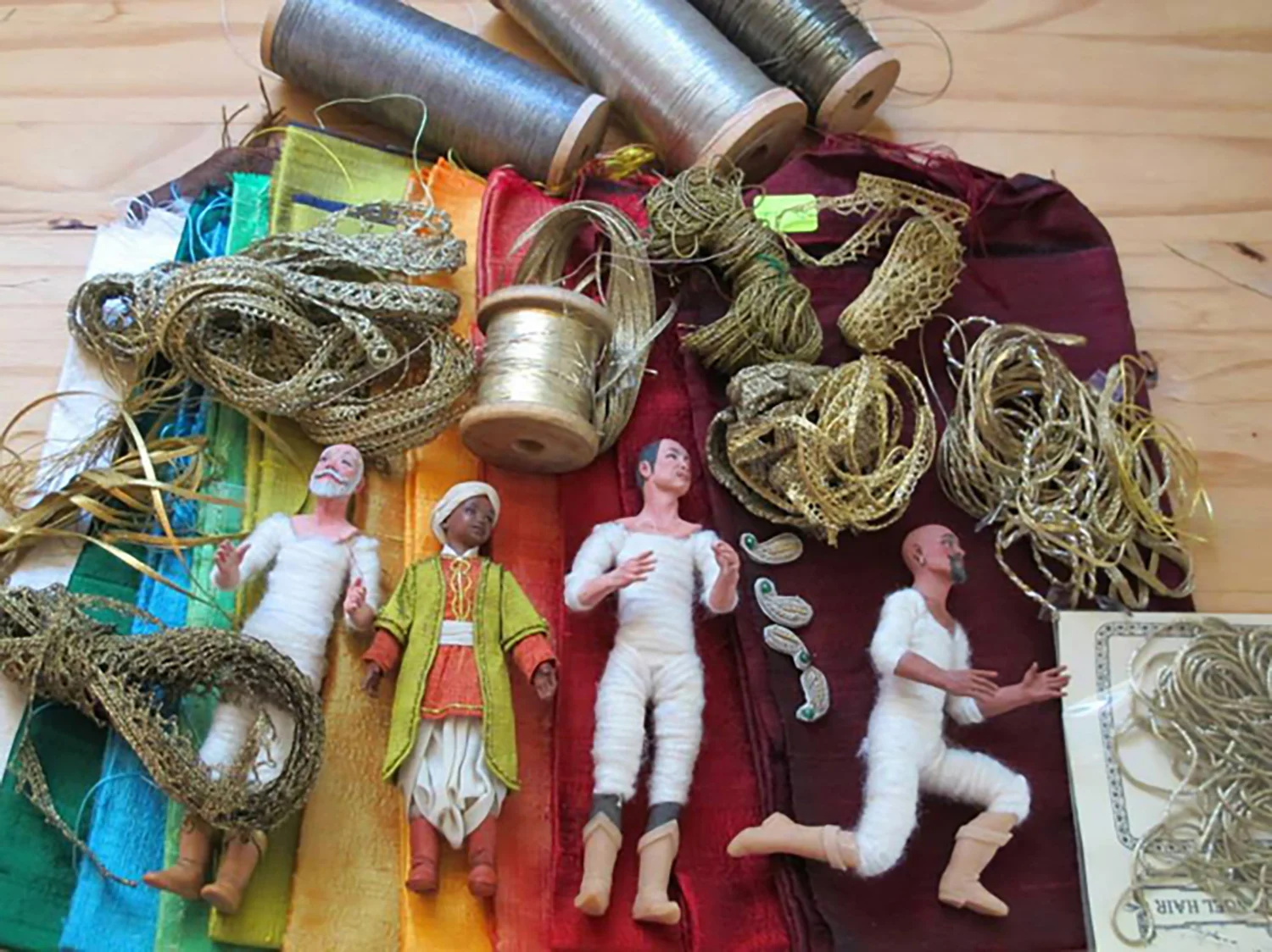 Figure 5: The three wise men and an attendant surrounded by the materials that will be used to dress them. Special silks were ordered from India.