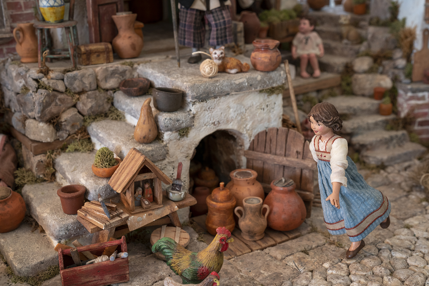 Figure 13: A young girl runs through her Italian village; a figure by Karen Loccisano. Note the small Nativity on the bench.
