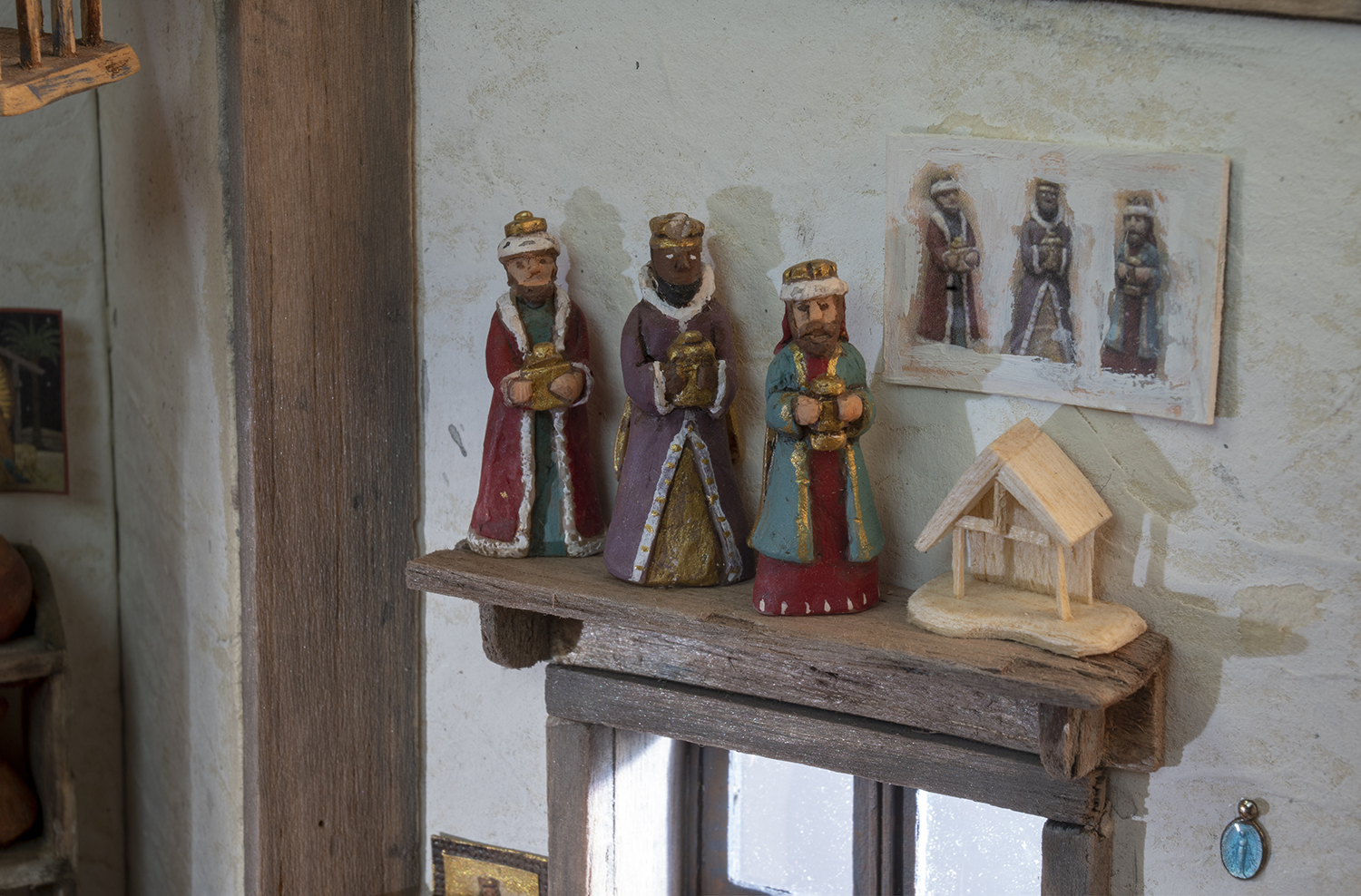 Figure 15: The wise men, an incomplete stable, and a blue pendant of the Virgin Mary. The pendant once belonged to R. Michael Palan’s mother, and was added to her rosary beads.