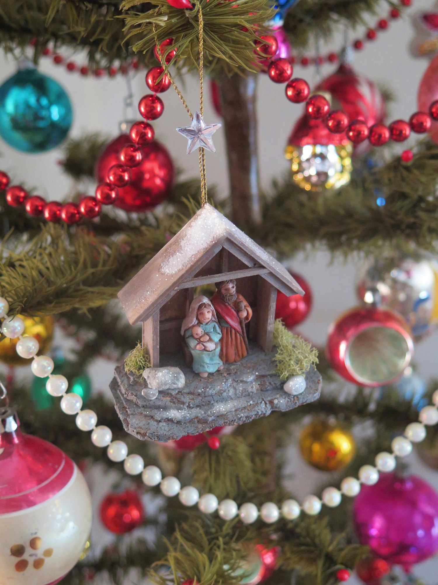Figure 21: A example of a completed Nativity ornament, designed to be made by workshop participants, hanging on a Christmas tree. Photo by R. Michael Palan.