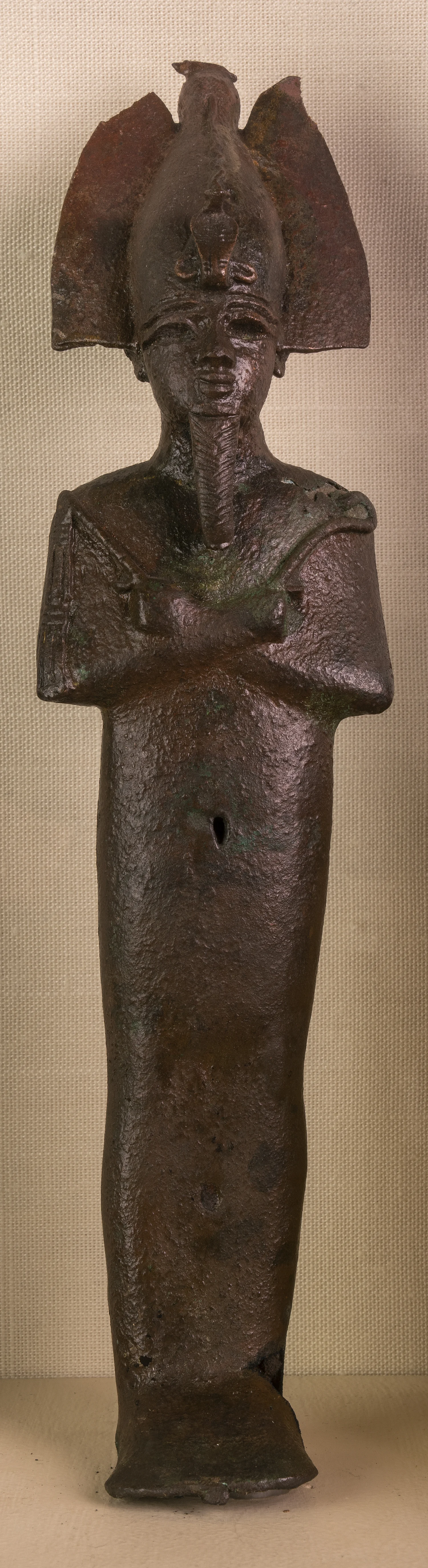Figure 5: Bronze votive statuette of Osiris (E74). The god is shown mummiform, wearing his usual crown and holding the crook and flail as symbols of his kingship.