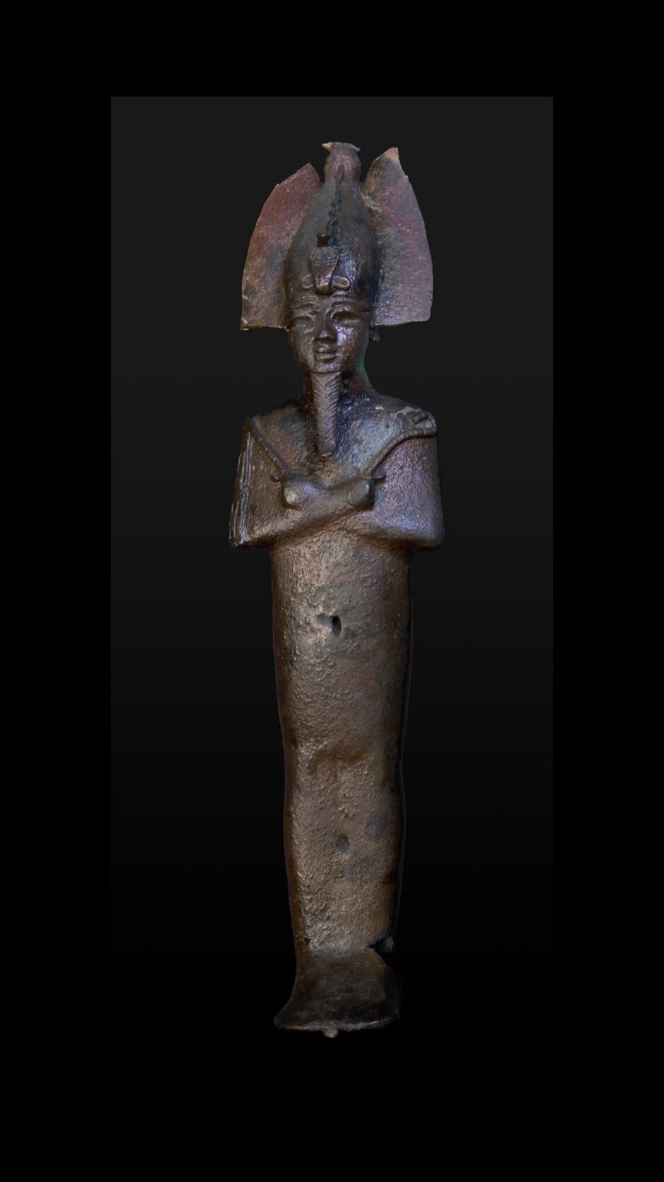 Osiris stands with his arms crossed across his chest.