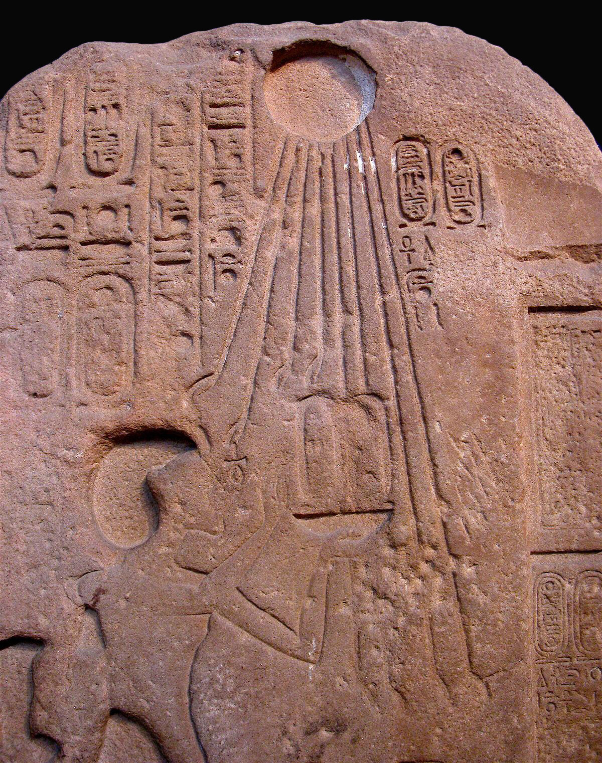 Figure 25. The Aten appears at the top of this relief fragment above a figure of King Akhenaten. Unlike other Egyptian deities, the Aten does not take a human or animal form. This deity is shown as a sun disk with rays that end in tiny hands (UPMAA E16230). Image courtesy of the Penn Museum.