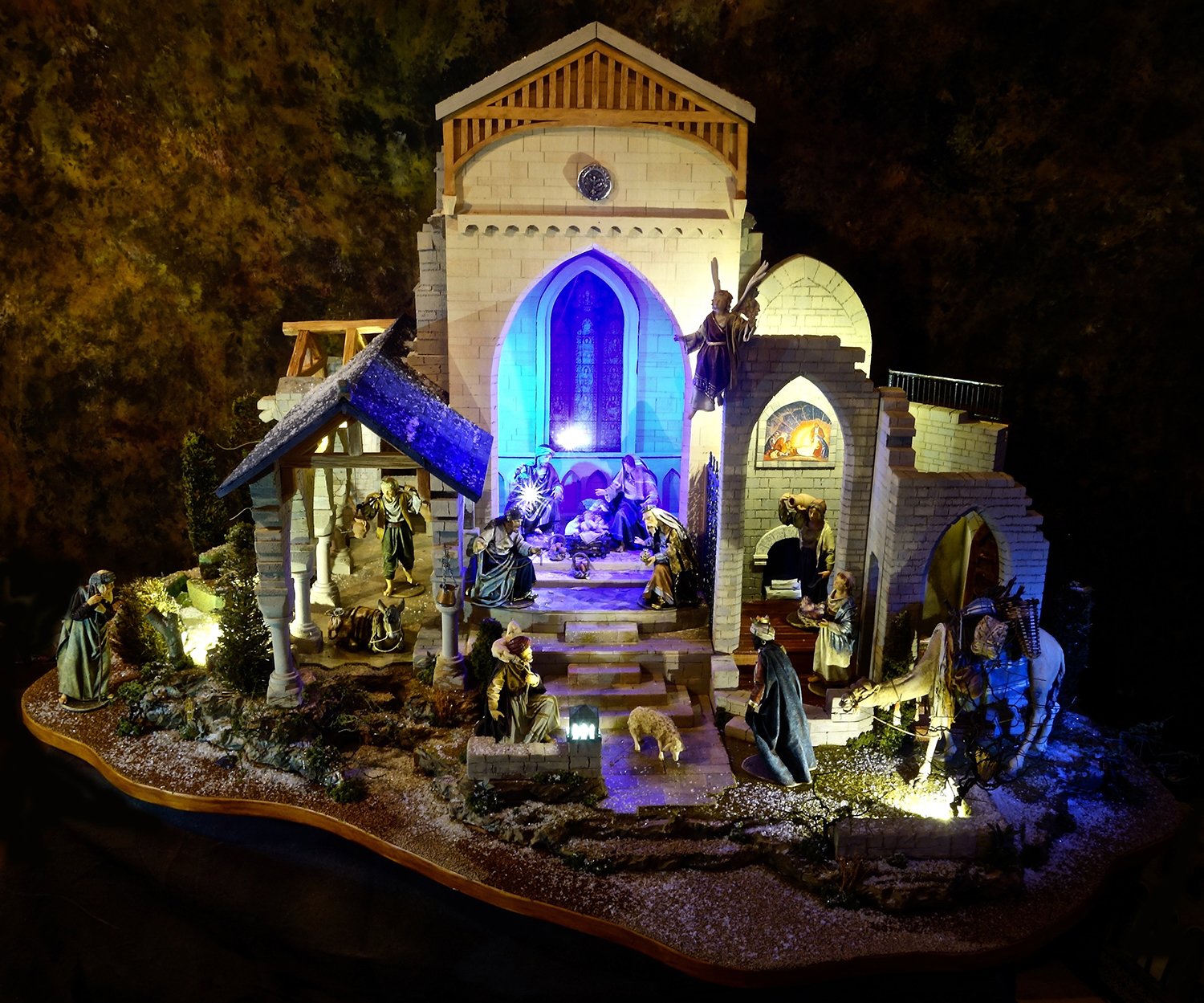  This Nativity has a setting by Navidad Nativities is based on architectural elements from both Glencairn and Bryn Athyn Cathedral, including stone walls and a "stained-glass window." The figures are made from wood and fabric by Original Heide, Val G