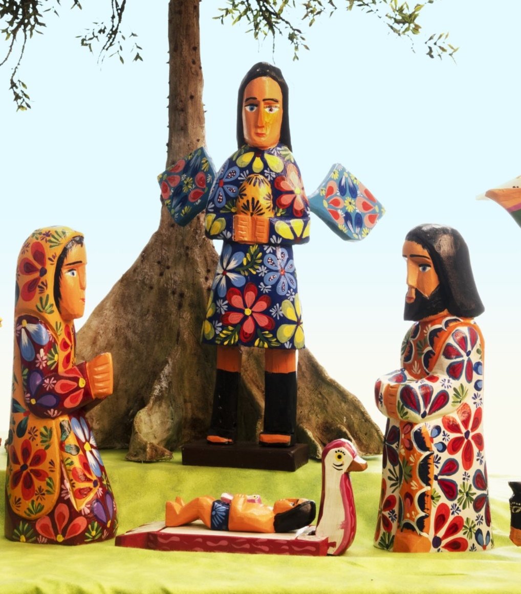 The Holy Family and an angel can be seen in this detail of a colorfully painted wood Guatemalan Nativity. The Christ Child lies in a manger made in the shape of a rooster. 