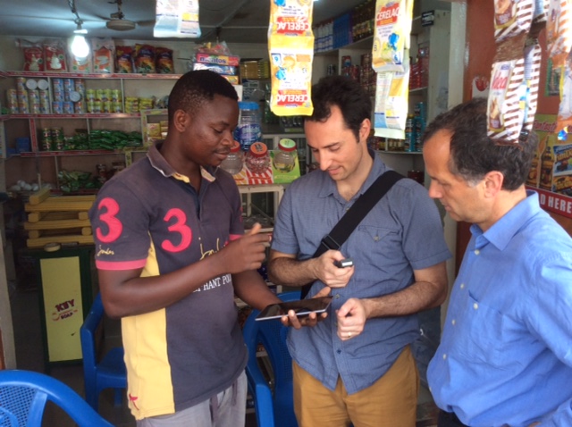 Shopkeeper in Accra showing BFA team how he uses smartphone app to run his business