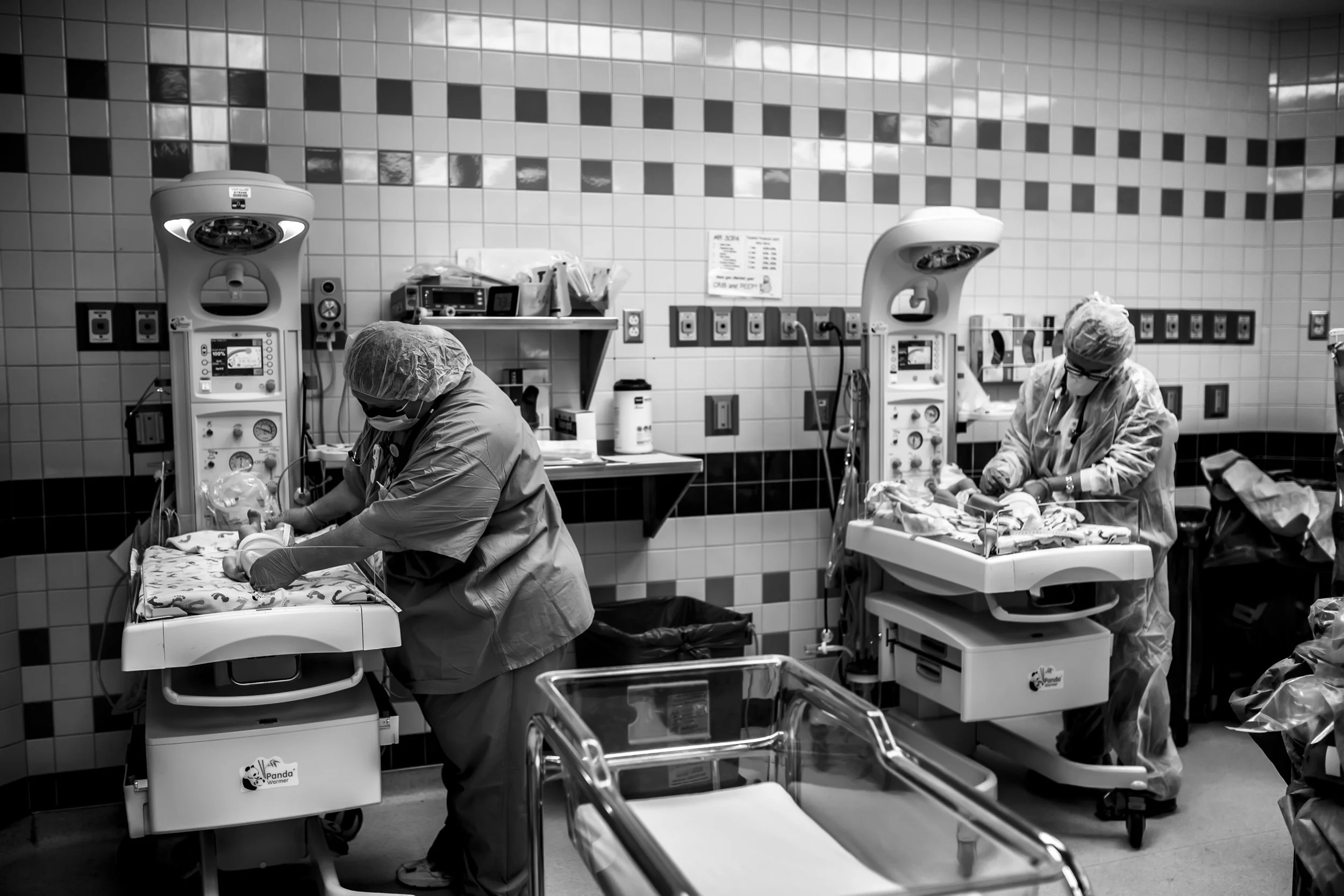 both twins with nurses after birth