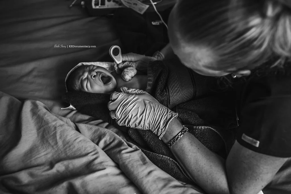 midwife doing newborn exam