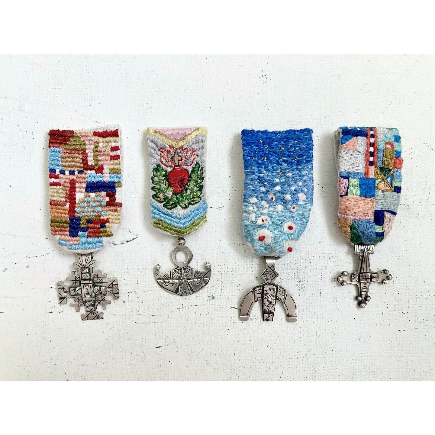 Finally finished this back burner project. Tuareg talismans meets military medals. Sterling silver, hand embroidery. Blue medal by guest embroiderist @yoshikojaeggi