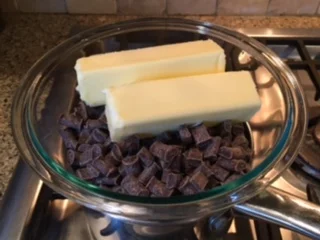 Melt chocolate chips and butter in a double boiler. I just use a glass bowl on top of a sauce pan with a few inches of water. Its best to leave untouched for awhile until completely melted. Stir with a whisk until chocolate is smooth. Remove from heat. Bring melted chocolate over to mixer and turn speed to low. SLOWLY add chocolate in a steady stream to egg mixture. You don't want to scramble the eggs! When all ingredients are fully incorporated, pour into a buttered springform pan.