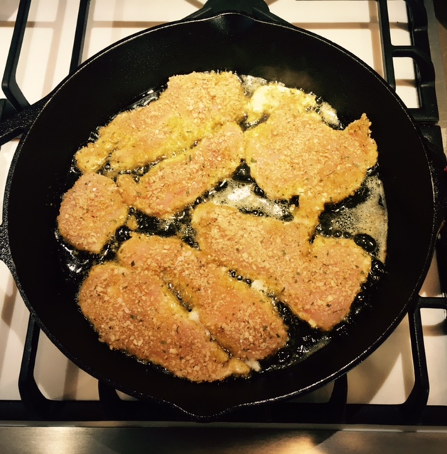 Chicken cutlets cooking in olive oil
