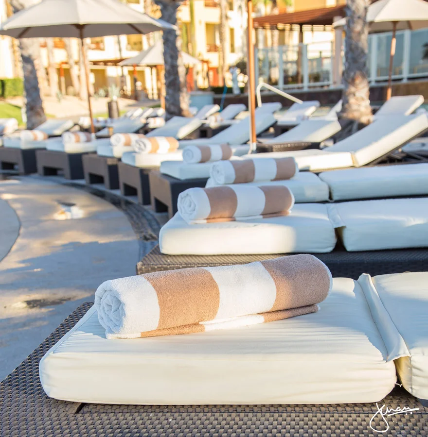Perfectly rolled up towels on pool loungers