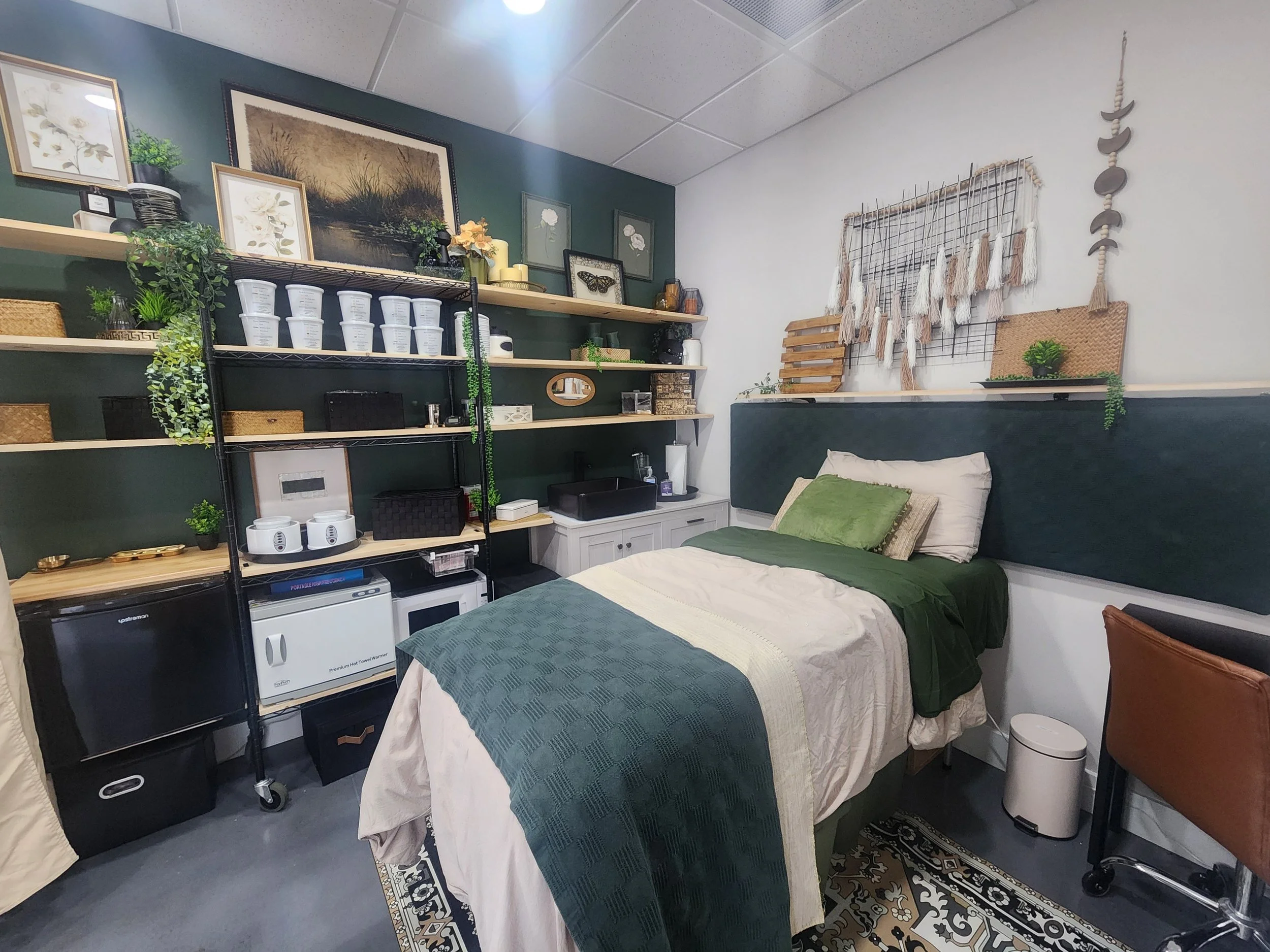 Cookeville Body Sugar Boutique treatment room with forest green walls and a sugaring treatment bed