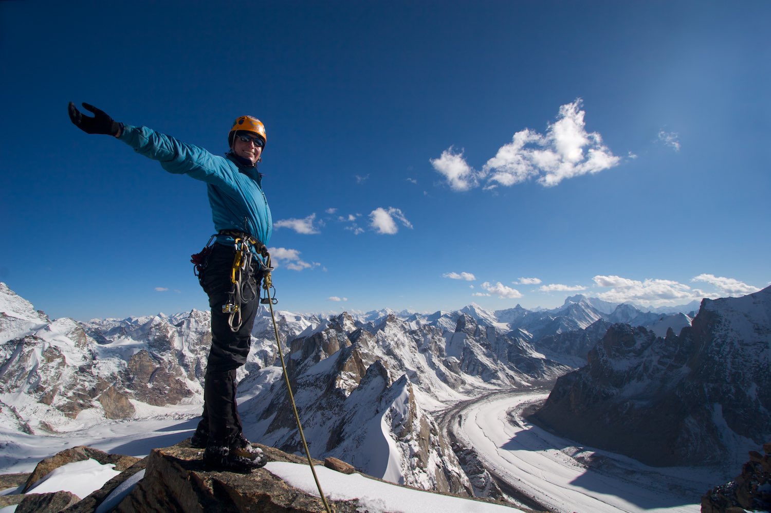 Natasha delighted to have made the first ascent of Triple Crown (5800m). The Neverseen chain of peaks is directly behind and the Tawa Glacier is on its right.