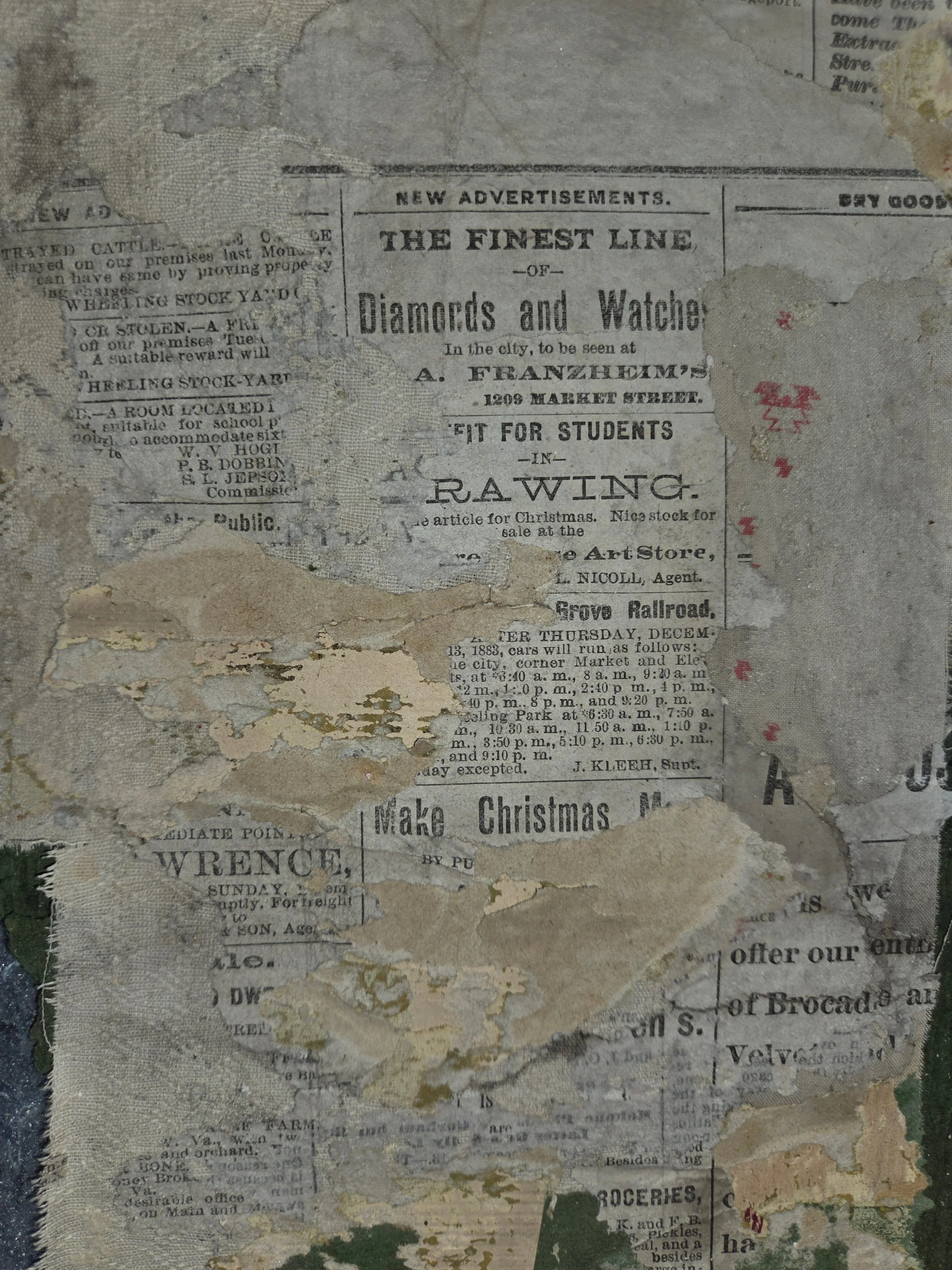 A weathered and partially torn vintage newspaper clipping with advertisements, including one for a jewelry store that sells diamonds and watches, and mentions about train schedules and Christmas events.