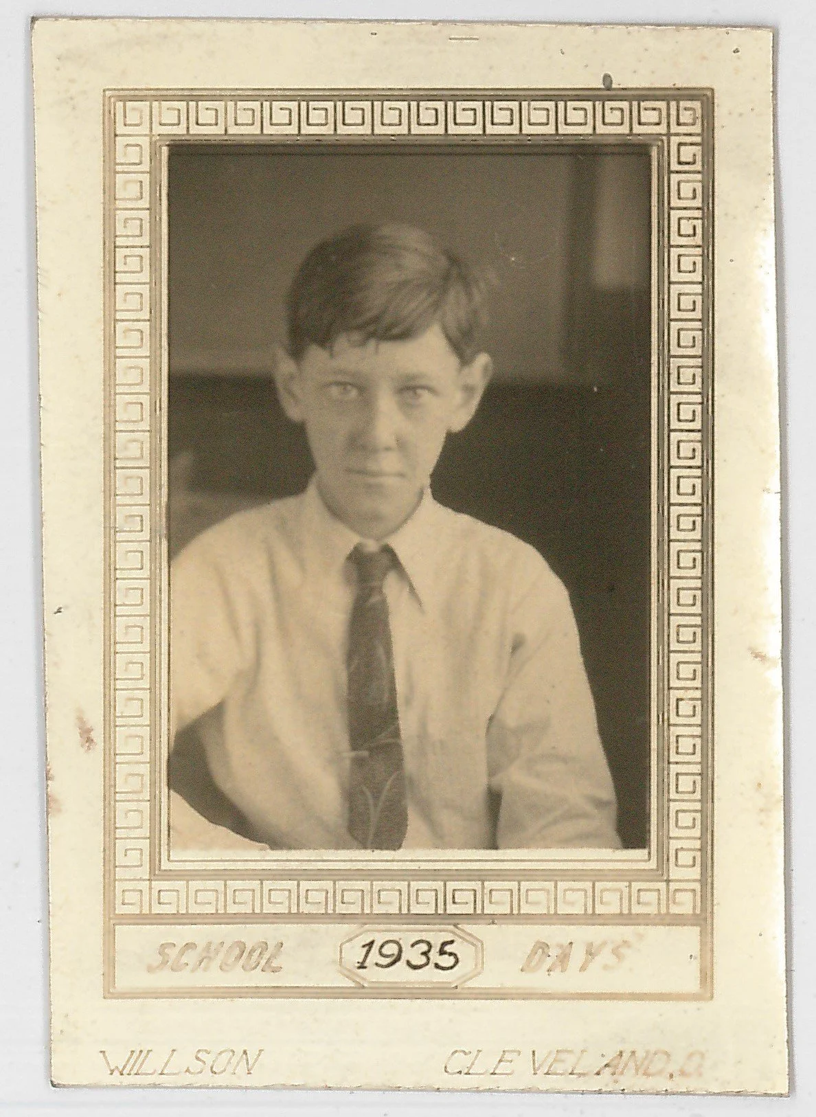 Black and white photograph of a young boy in a school photo from 1935, wearing a collared shirt and tie, with text indicating his name as Willson Cleveland.