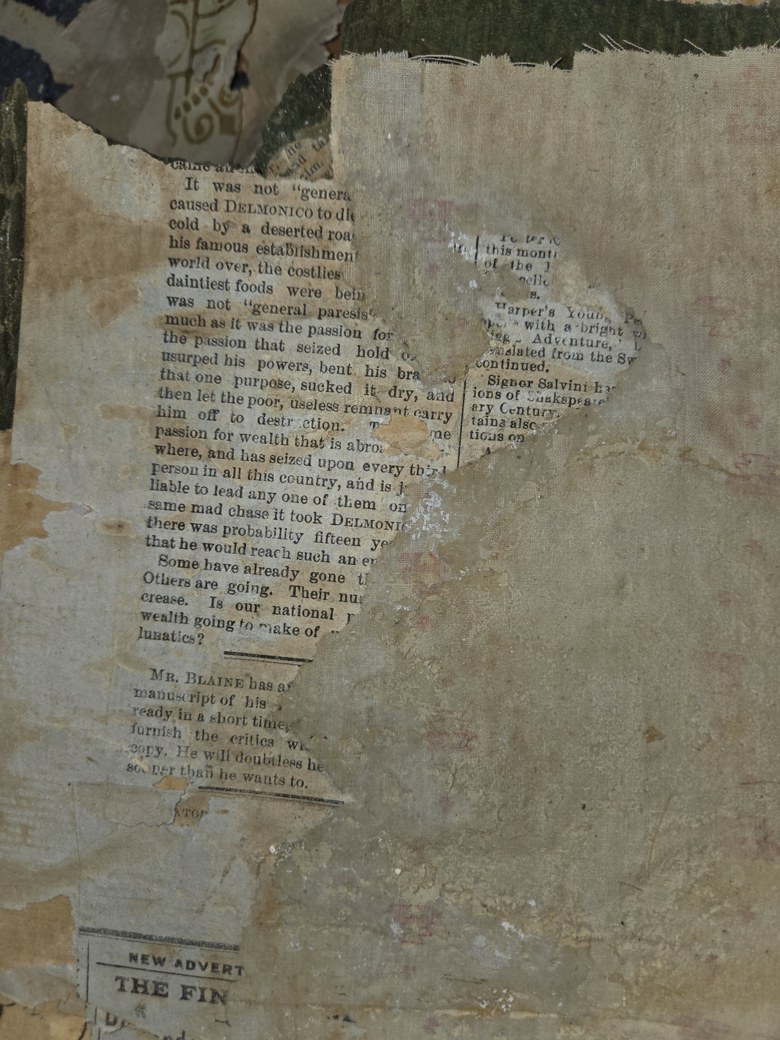 A collage of torn, overlapping pieces of old newspaper and paper on a textured surface, some areas stained or weathered.