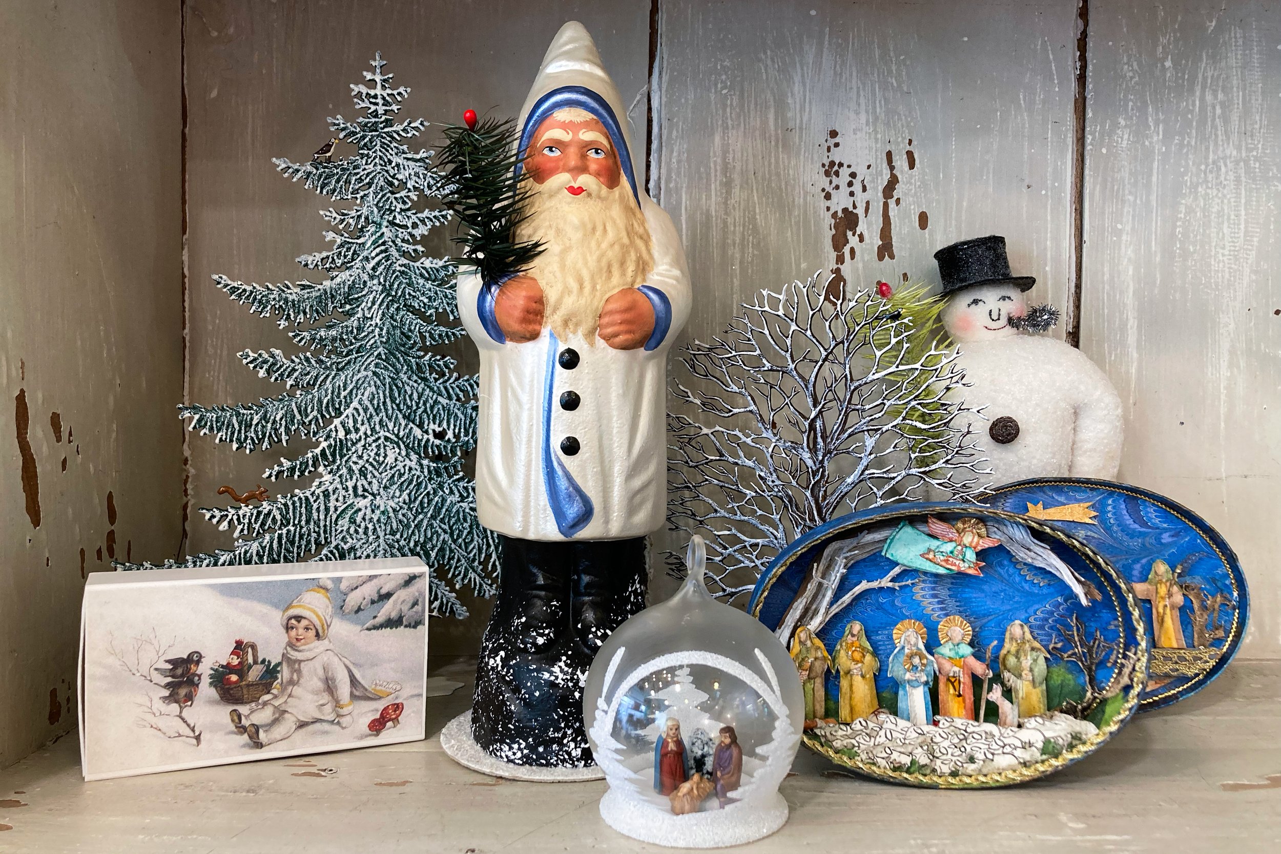 kunstvoll von Hand hergestellte Weihnachtskrippe in ovaler Holzschachtel mit  krippenszene. Exklusive Weihnachtsdekorationen: Papier Mache Nikolaus, Watte Schneemann, Zündholzschachtel mit Wintermotiv, Weihnachtskugel mit dreidimentsionaler Krippensz
