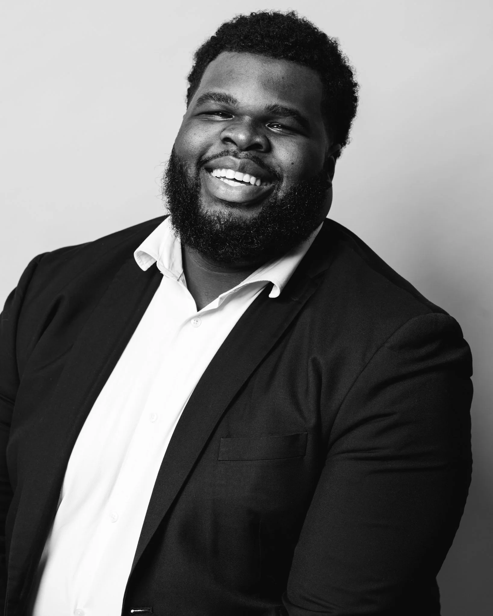 Black and white executive headshot of a smiling professional man, photographed by Richmond headshot photographer Scott Photography.