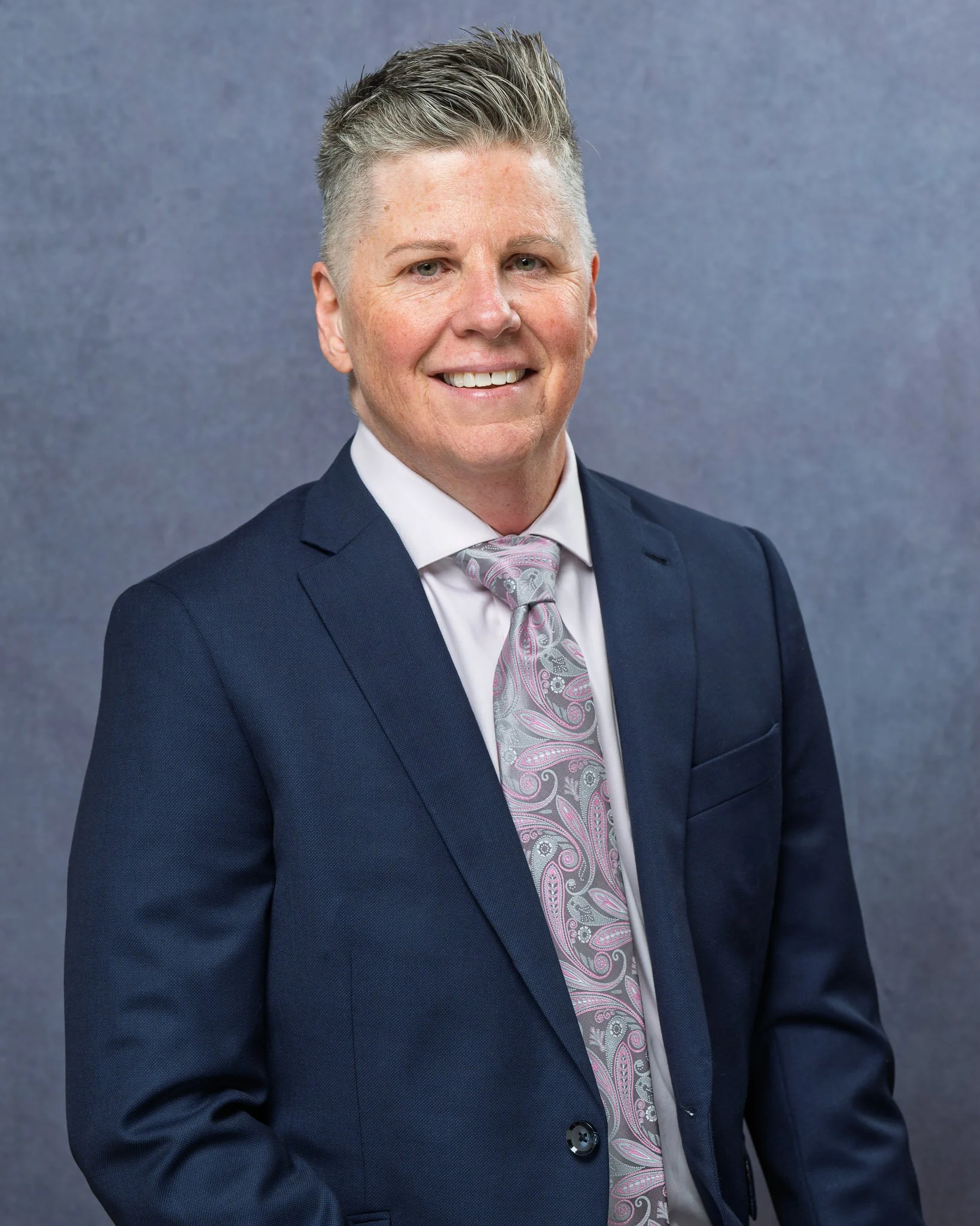 Professional executive headshot of a business leader wearing a suit and tie, photographed against a gray studio background in Richmond, Virginia by Scott Photography.