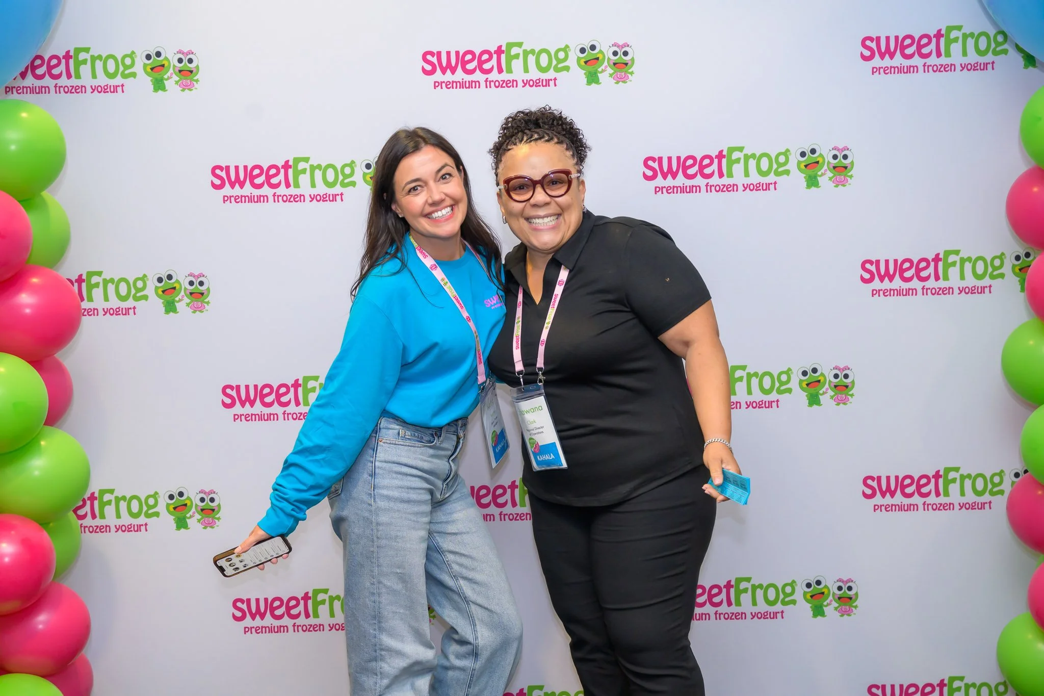 Corporate event photography featuring branded step-and-repeat backdrop at a business activation, showcasing sponsor visibility and guest experience.