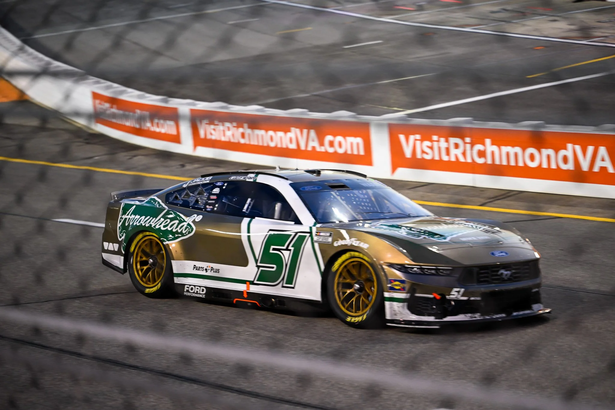 NASCAR race car speeding through Richmond Raceway during a nighttime motorsports event, photographed by Scott Photography.