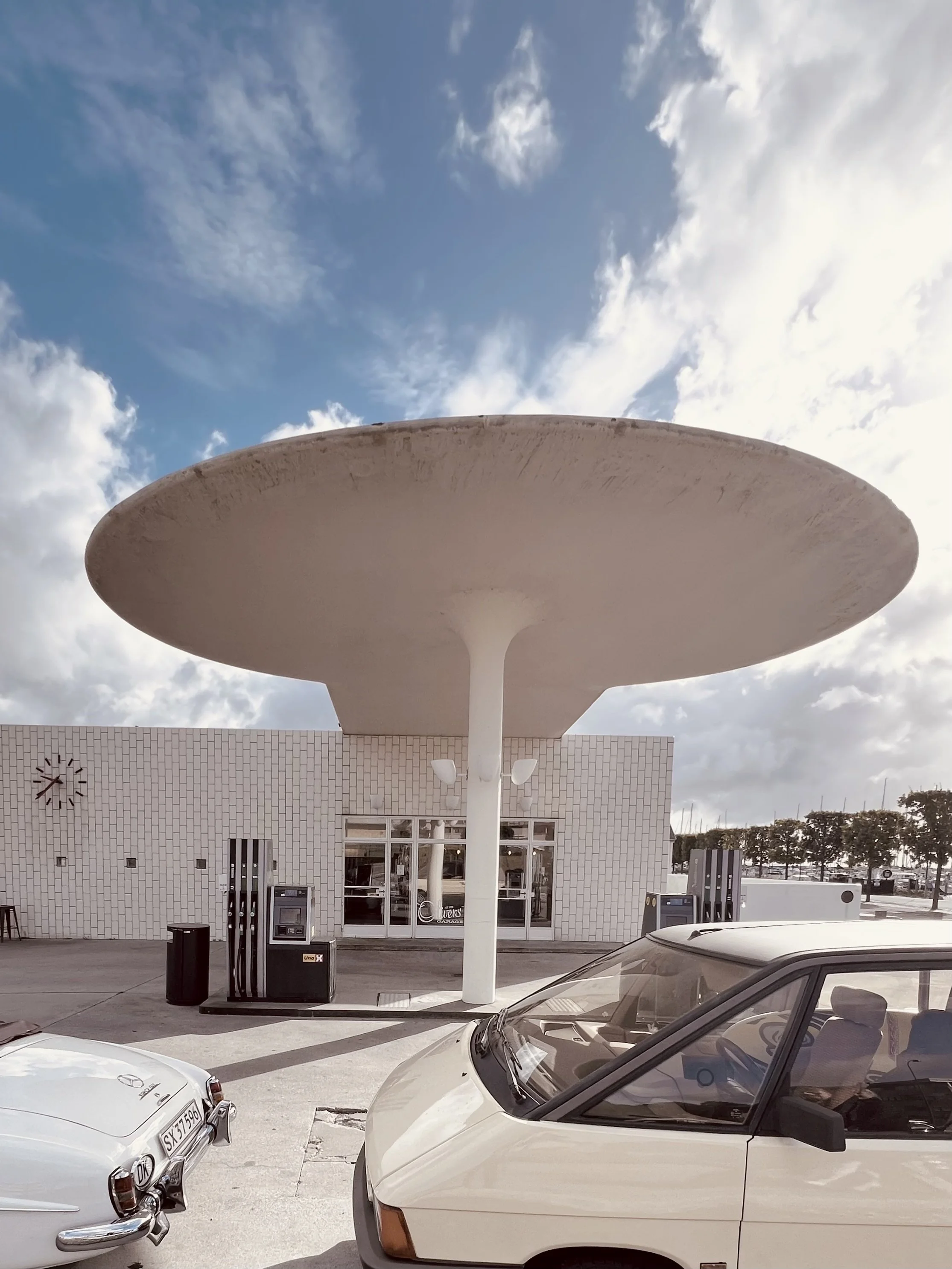 Tankstelle mit runden Betondach vor blauem Himmel, von Arne Jacobsen