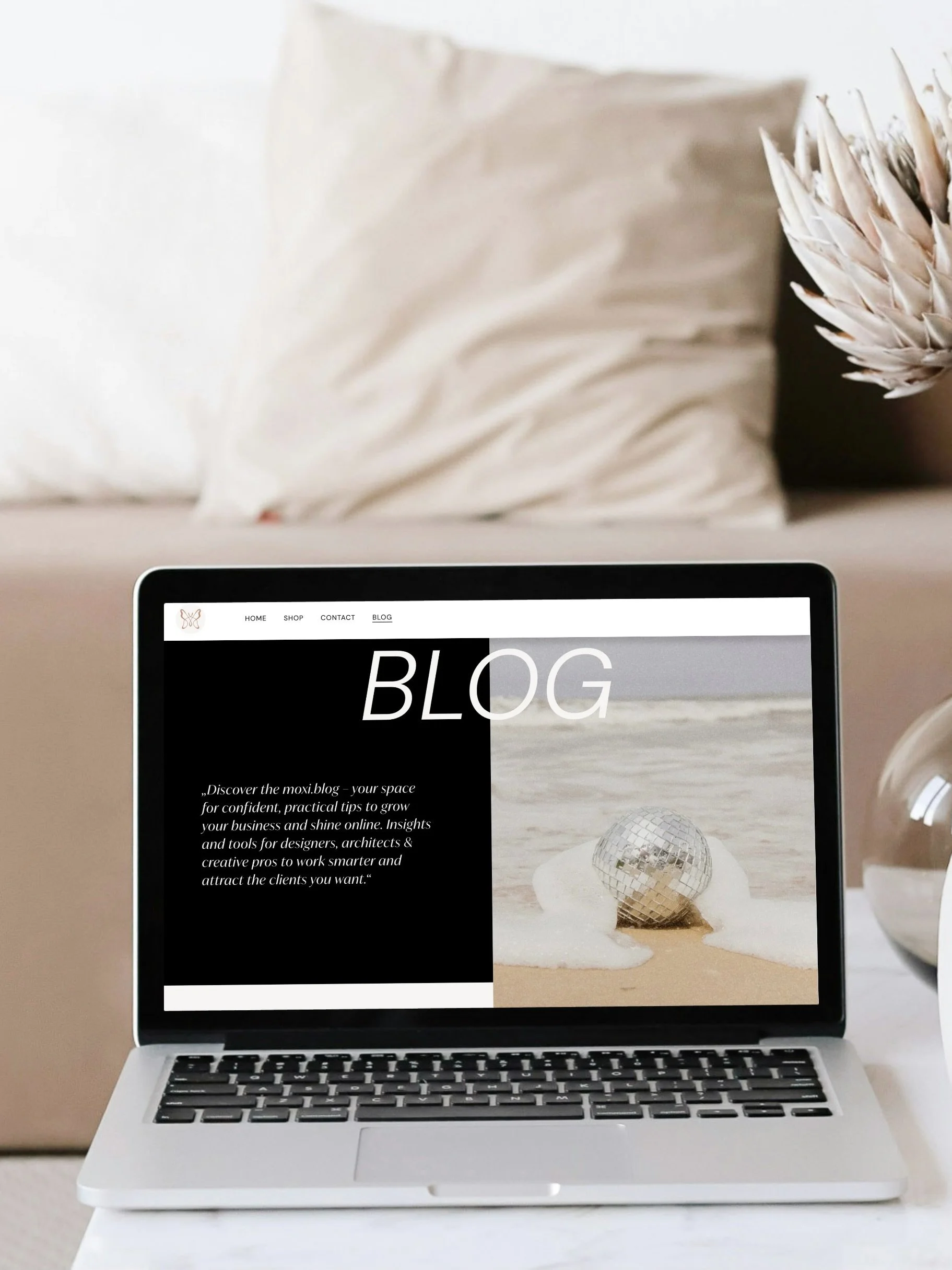 Macbook auf Tisch vor Sofa