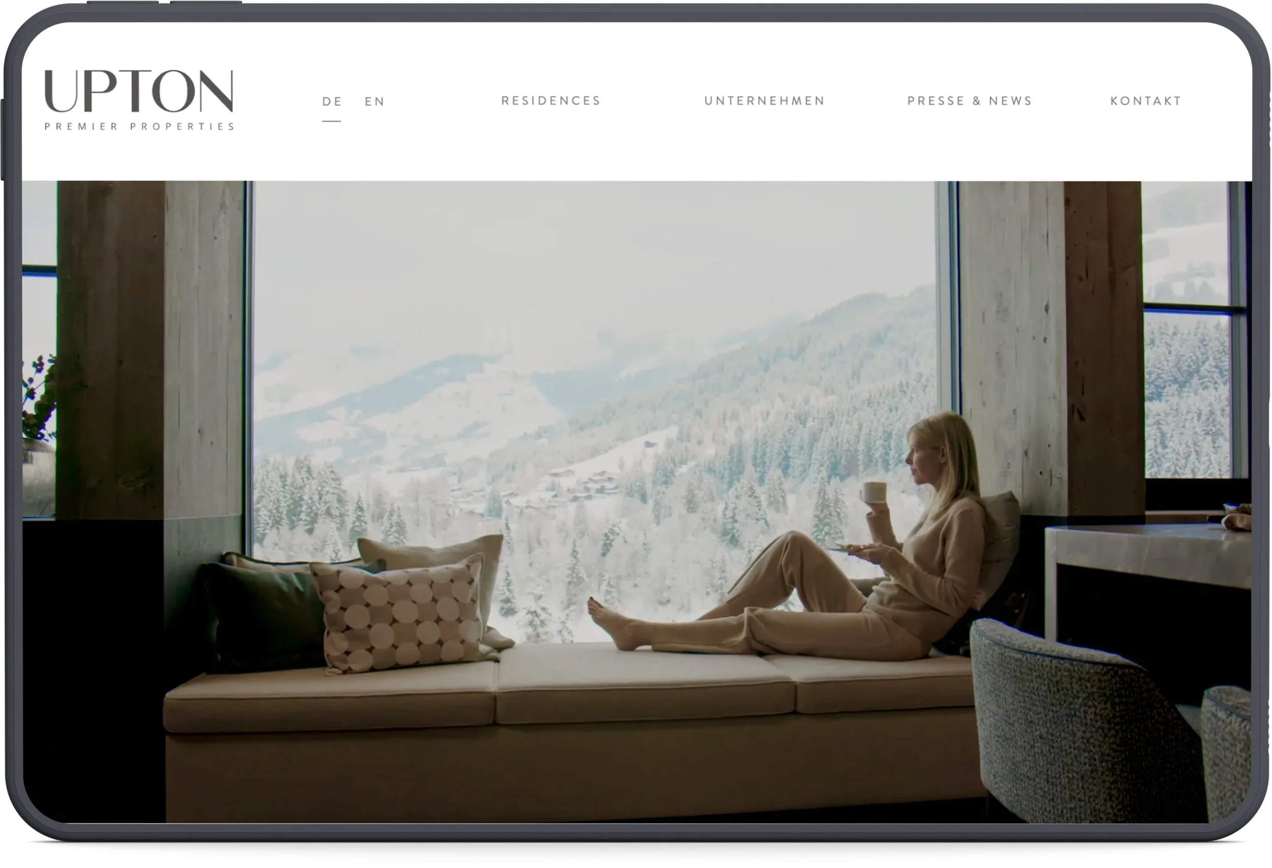 iPad mit Sreenshot Immobilien, Frau mit Tasse vor Fenster