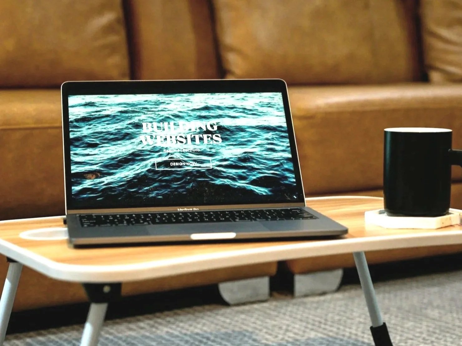 Klapptisch mit Laptop vor LederCouch