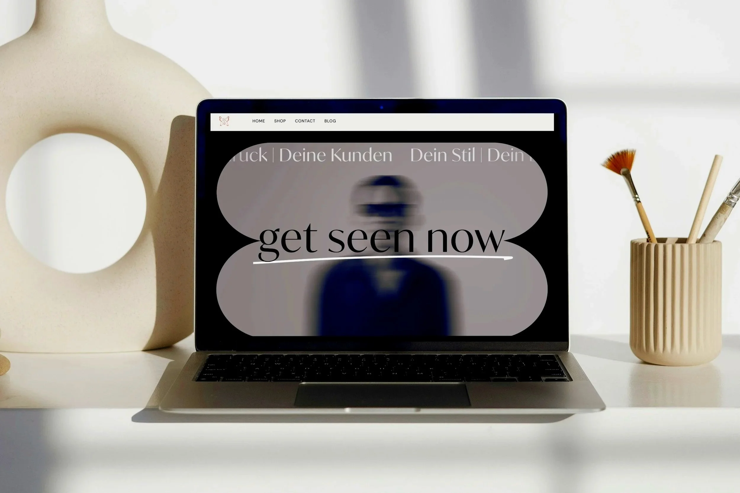 Ein Laptop auf weißem Tisch mit einer Grafik und Person, verschwommen