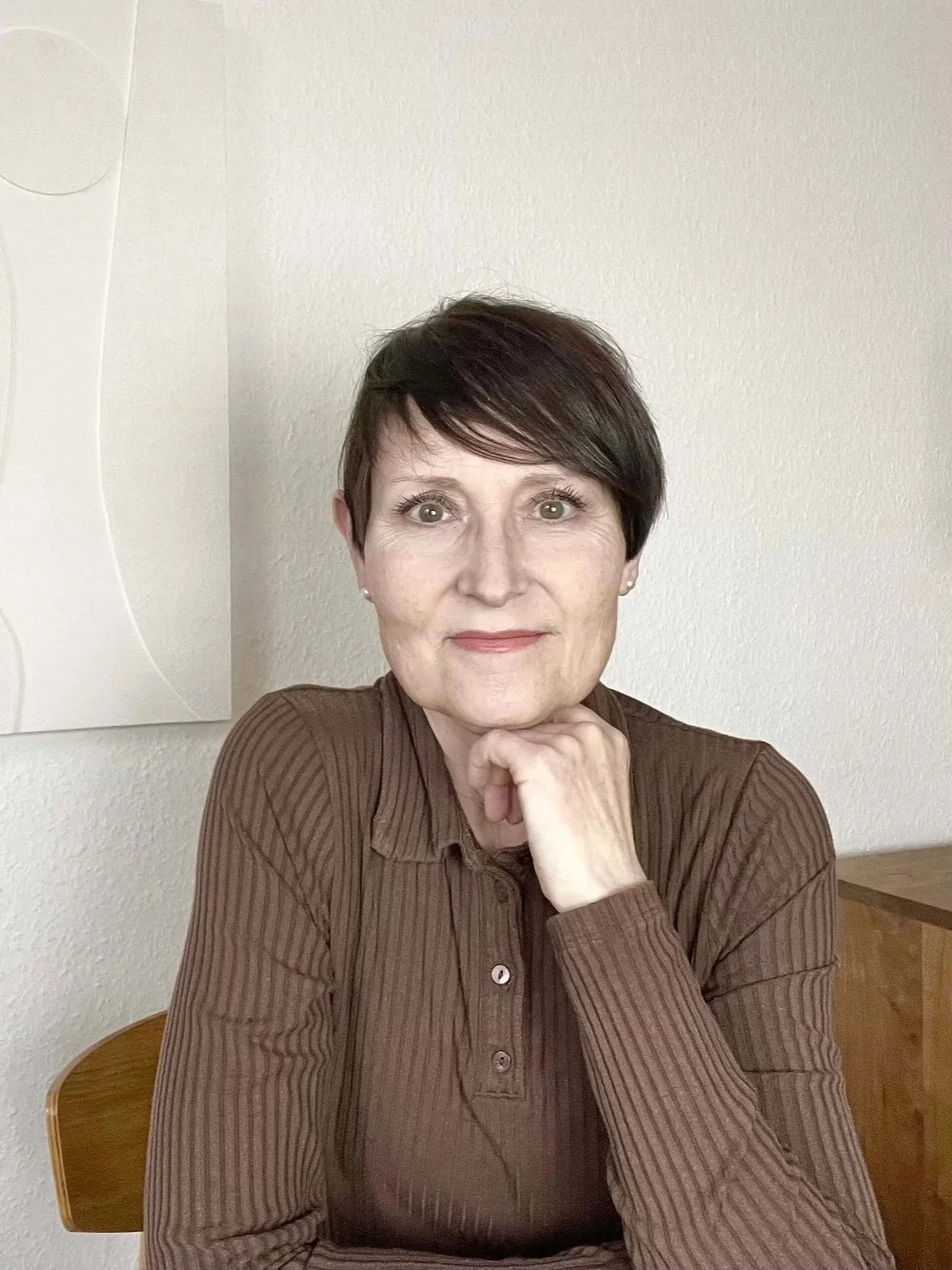 Frau mit kurzen braunen Haaren im braunen Poloshirt