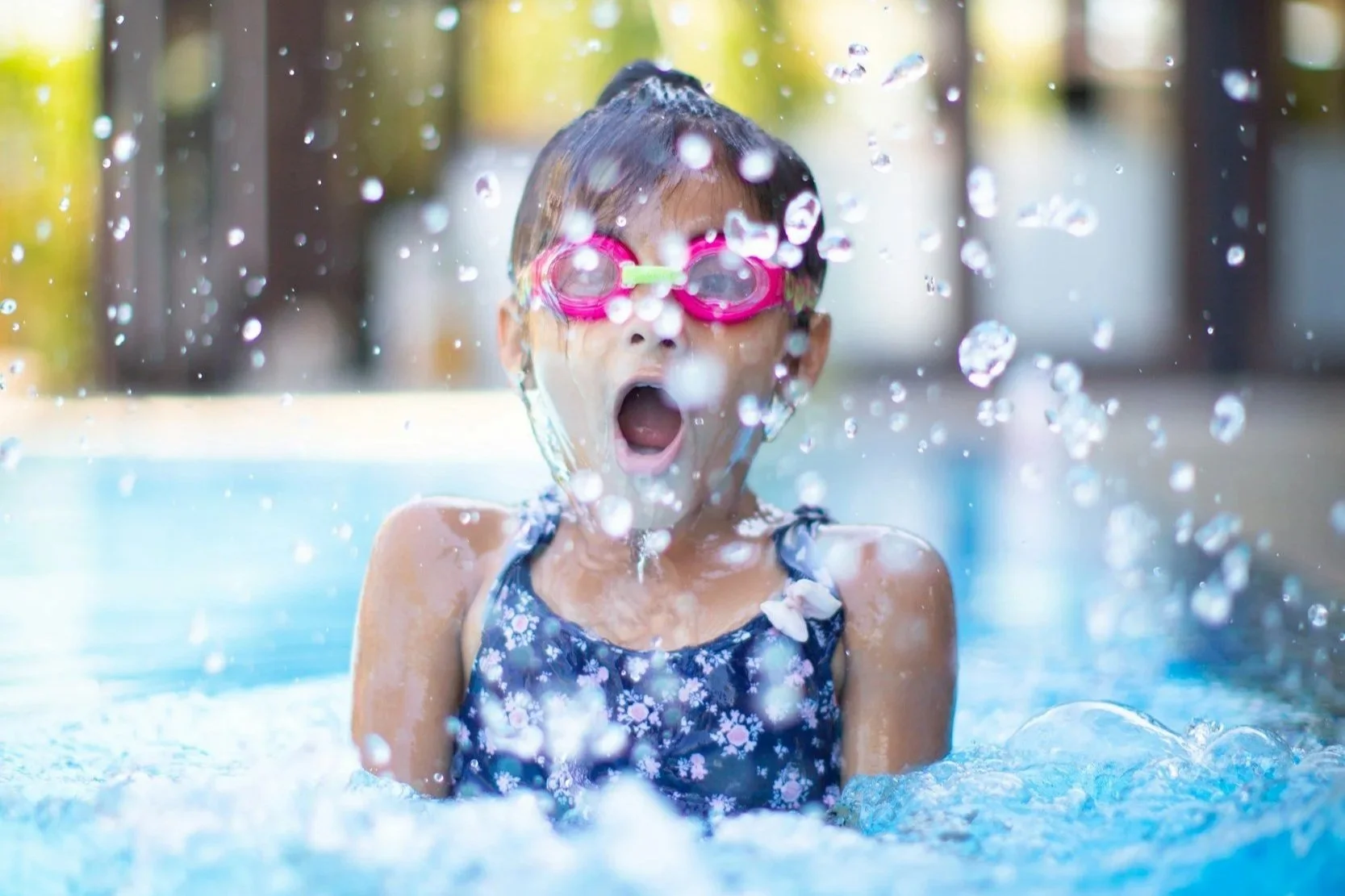 Kleines Mädchen mit Schwimmbrille im Wasser