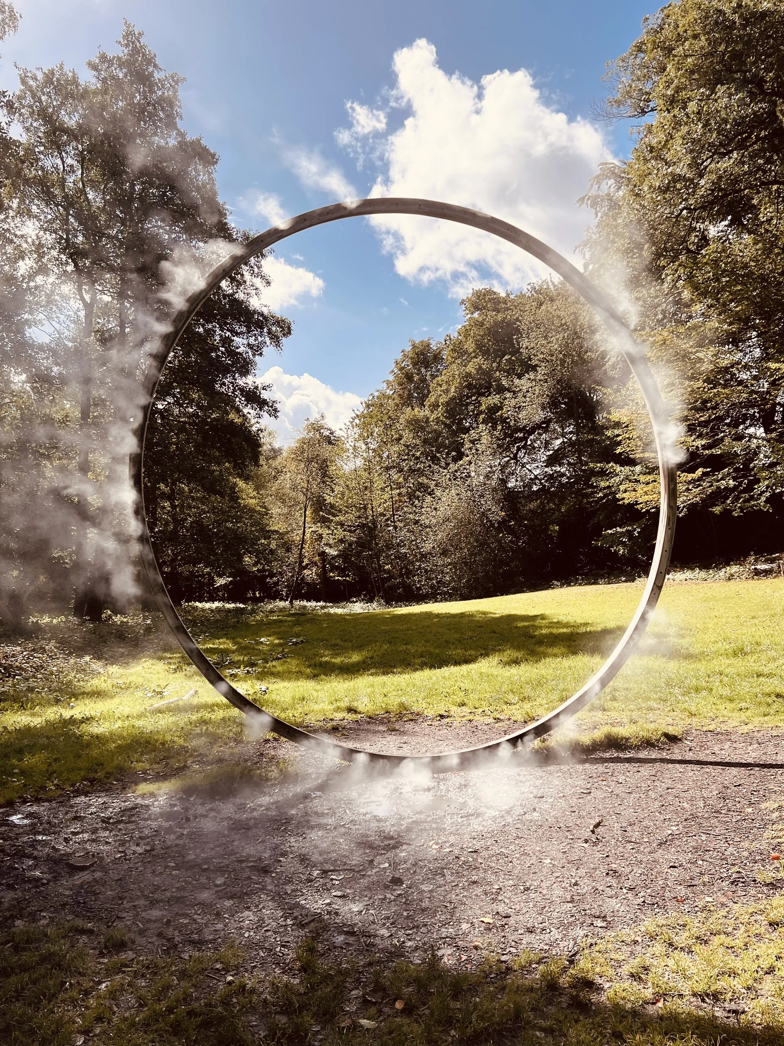 Stahlring in Landschaft, der Dampf absondert, Installation